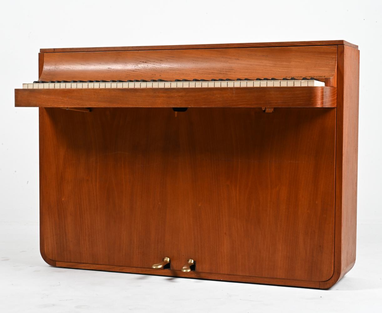 Step back in time with this masterfully-crafted Danish Mid-Century Teak Pianette by the renowned Louis Zwicki. From the heart of the 1960's, a period when design and craftsmanship merged in perfect harmony, this pianette encapsulates the very