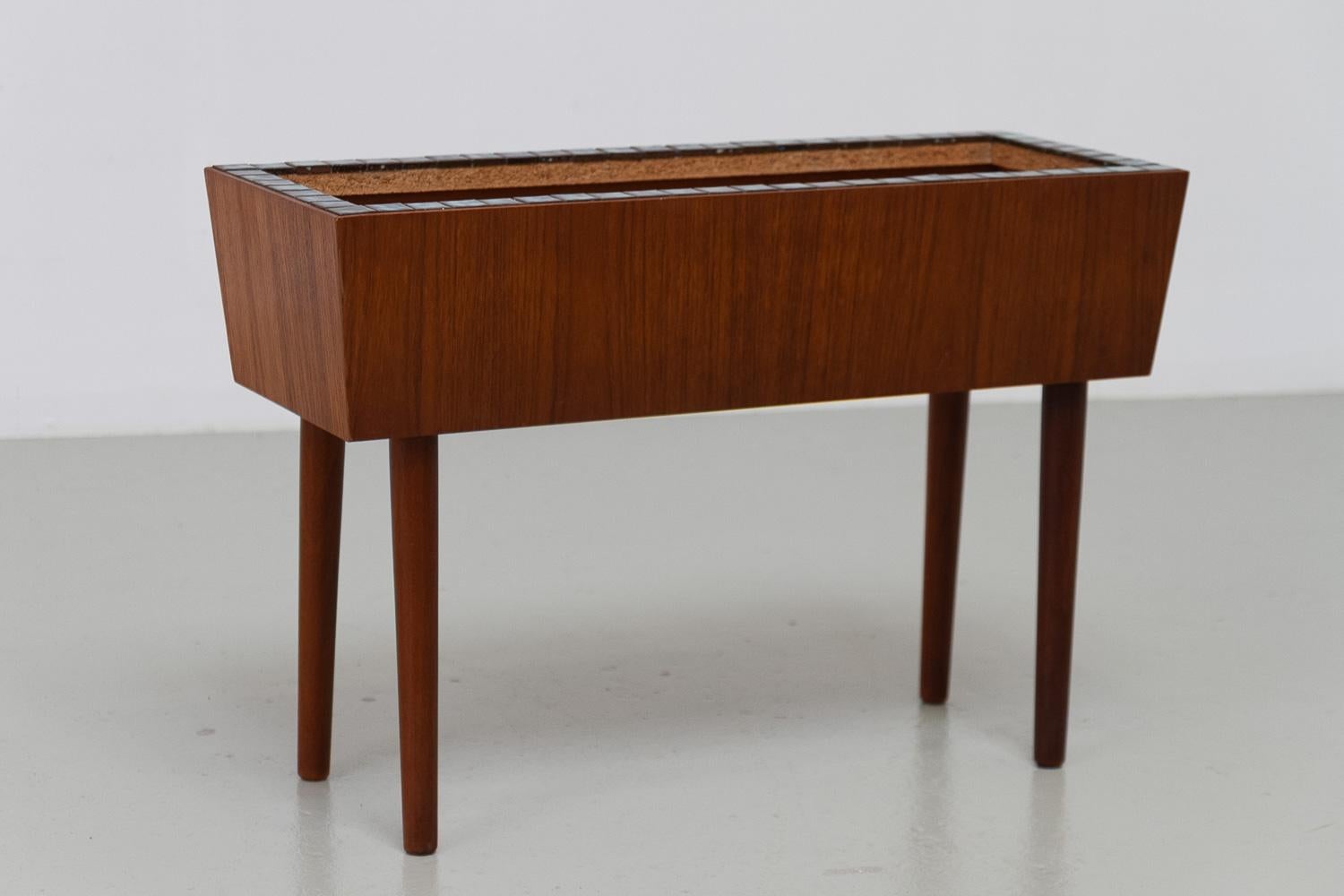 Fioriera danese di metà secolo in teak, anni '60.

Fioriera scandinava del Mid-Century su alte gambe affusolate e rotonde con intarsio decorativo di piccole piastrelle lungo il bordo.

Buone condizioni vintage. Pulito e lucidato, pronto per l'uso.