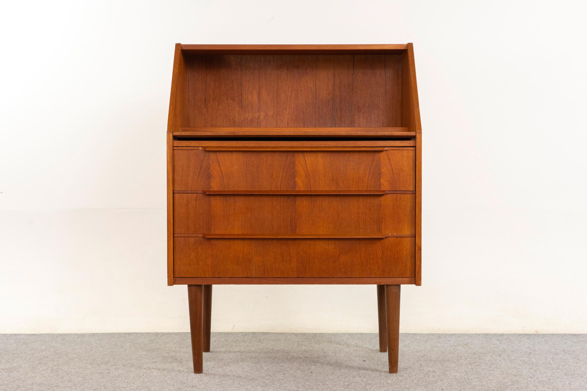 Teak Danish secretary desk, circa 1960s. Teak veneer with lovely grain match-up. Chest of drawers with sleek handles, open cubby, and pull-out work surface!

An unrestored item with the option to purchase in restored condition for an additional $350