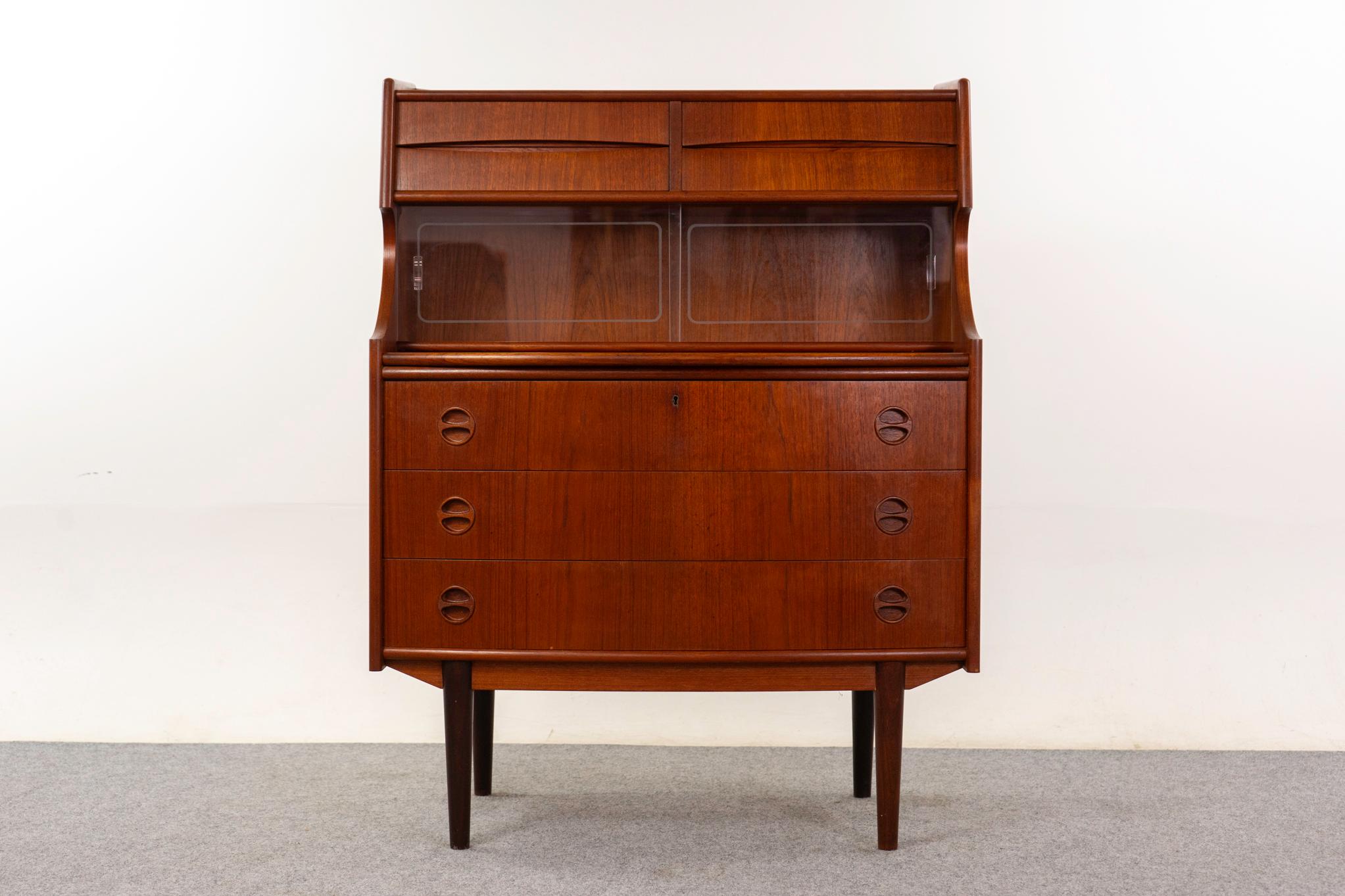 Dänischer Sekretär aus Teakholz, ca. 1960er Jahre. Schönes Buchfurnier, schwalbenschwanzgefertigte Schubladen, integrierte Griffe und schlanke Beine. Elegante Bogenfront, Kommode, Glasschiebetüren und eine ausziehbare Arbeitsfläche!

Ein