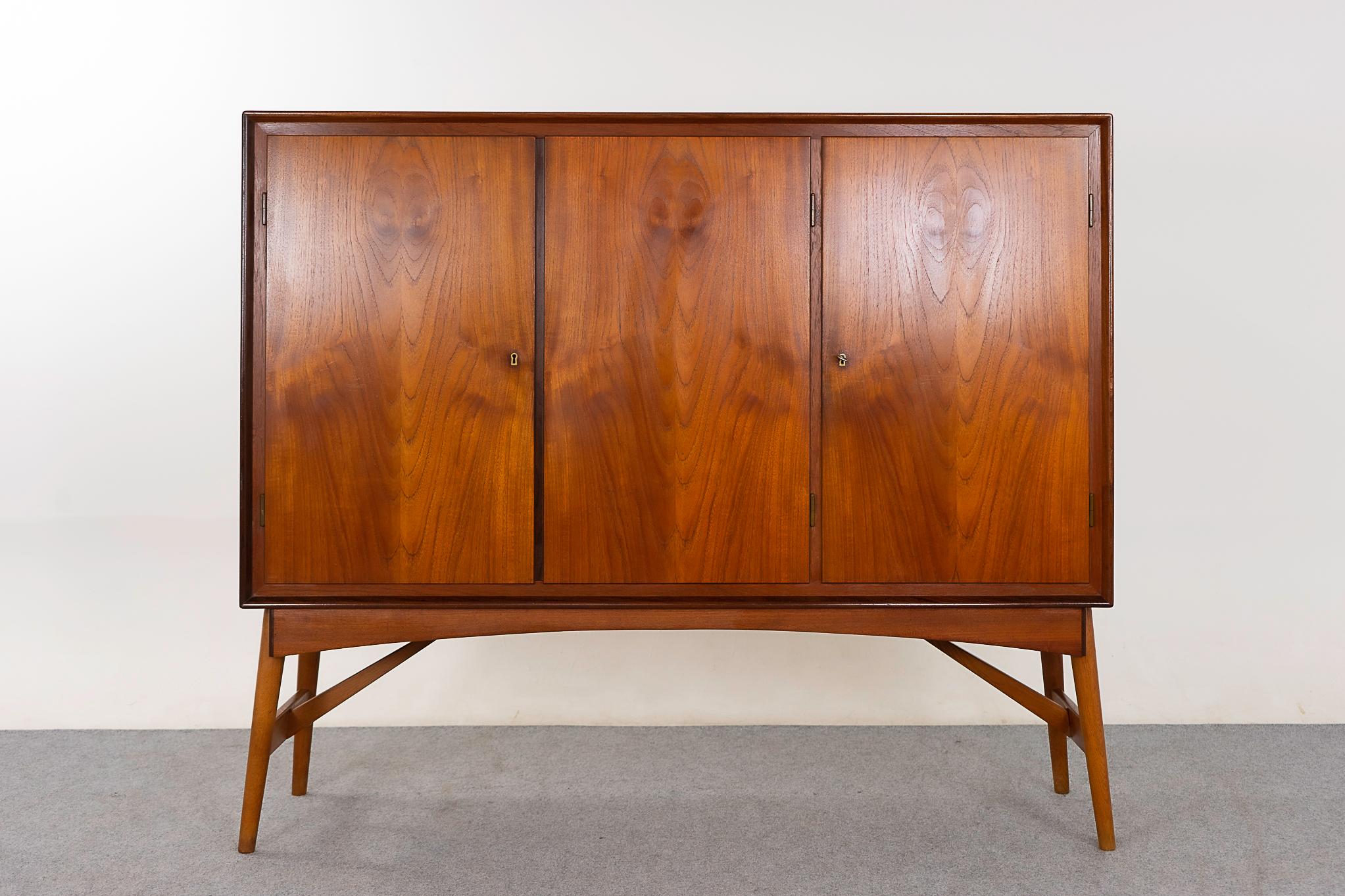 Teak & oak Danish sideboard, circa 1960's. Stunning veneer and the top and door faces. Sculptural angled oak base contrasts beautifully with the warm tone of the top. Behind the lockable doors, adjustable shelving and a darling set of sleek drawers