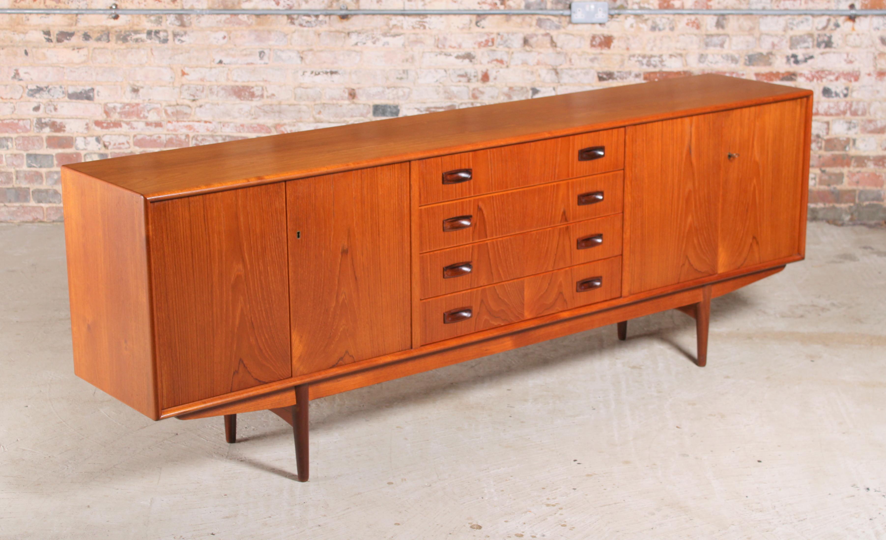 Danish Mid Century teak sideboard with carved rosewood handles, circa 1960s. 2 lockable cabinets and 4 drawers. The back is also beautifully veneered, so could be placed in the middle of a room. 

Dimensions: 219 W x 42 D x 78 H cm.