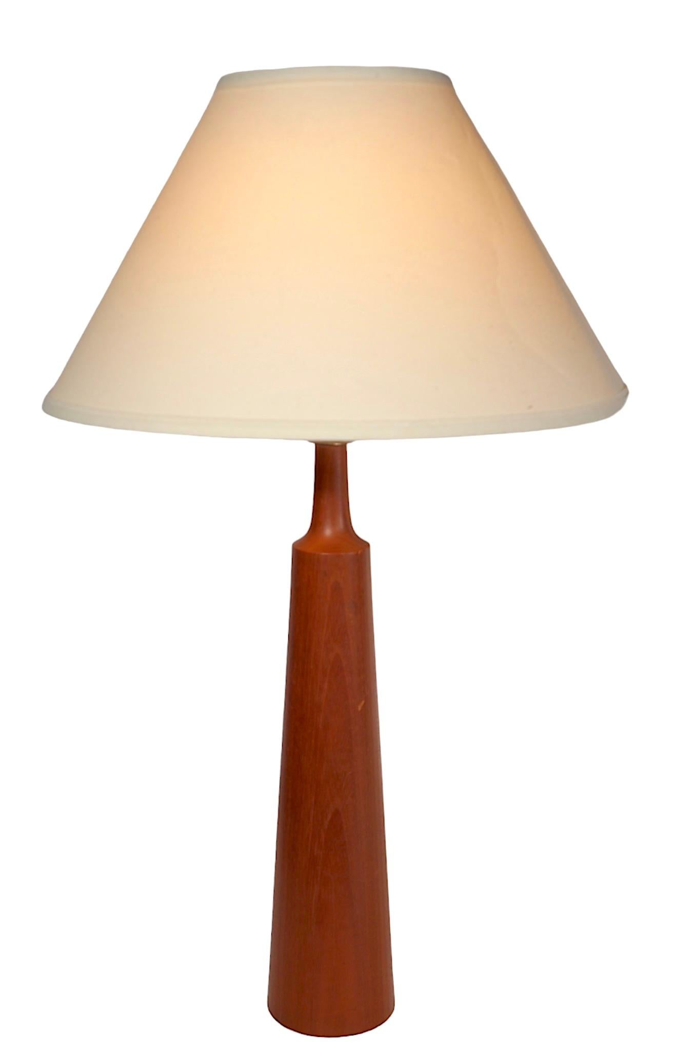 Classic Danish Mid Century Modern table lamp constructed of solid teak, circa 1950/1960’s. The lamp is of bottle form with a tapered cylindrical body, and tapering pole neck. This example is in very fine, clean, original, and working condition,