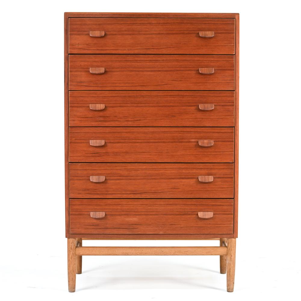 A Danish mid-century tall chest of drawers designed by Ejvind A. Johansson for FDB Mobler, c. 1960's. Featuring a six-drawer teak body on an oak base.