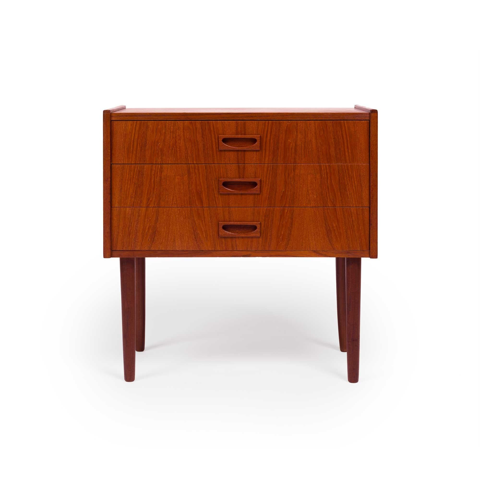 A vintage Danish teak chest with a beautiful teak grain. This small chest is a perfect size to be used as an accent or entryway table or nightstand. This chest has three drawers with beautifully sculpted drawer pulls. This chest, recently imported