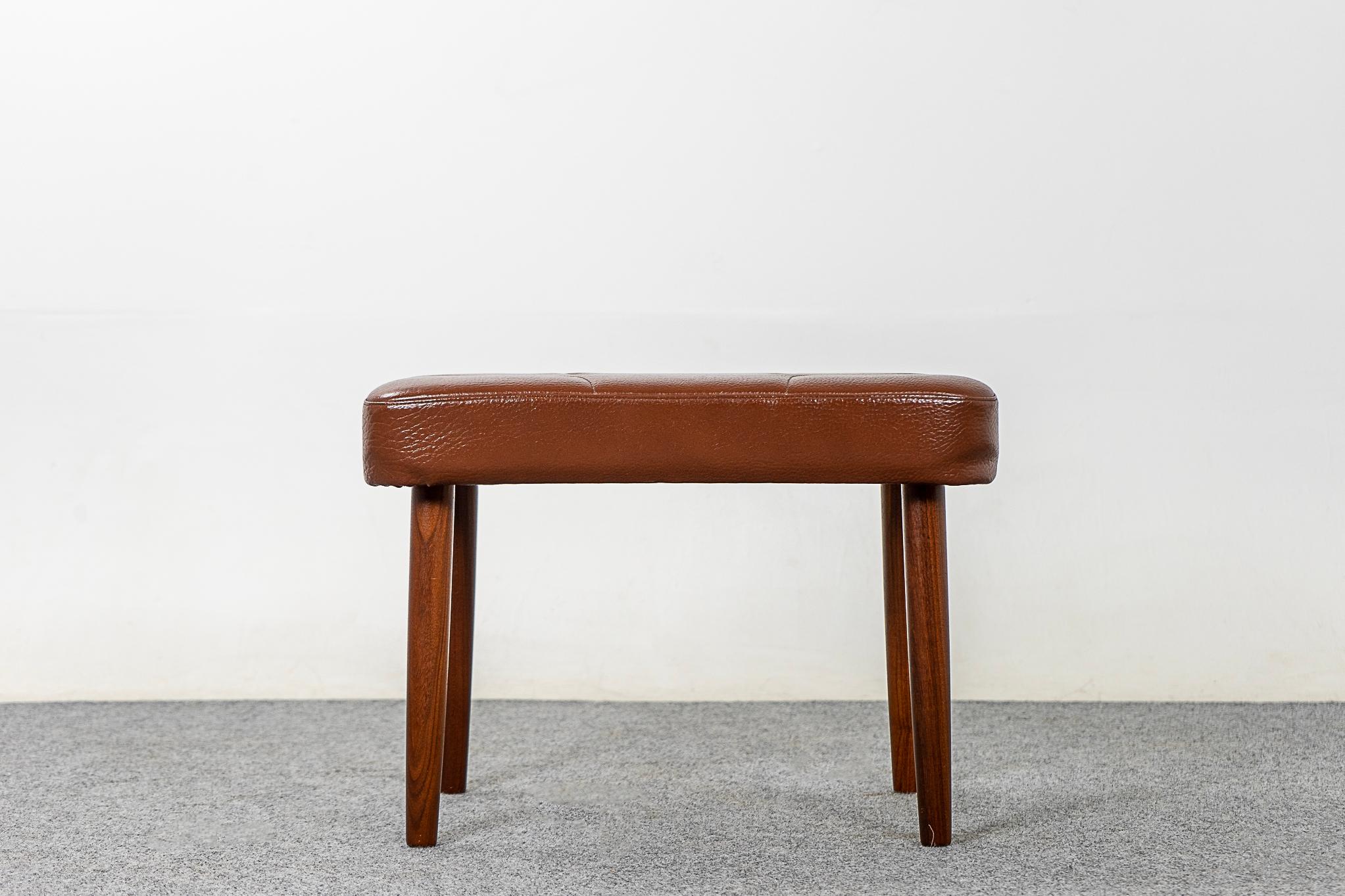 Teak & vinyl Danish footstool, circa 1960's. Charming quilted motif on caramel colored vinyl. Sleek conical legs that remove. Minor wear, typical of use and age.

Please inquire for international and remote shipping rates.