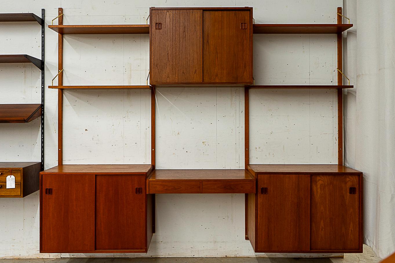 Danish Mid-Century teak wall system, circa 1960's. Fantastic wall system with solid wood trim, dovetail construction, stunning book-matched veneer and metal armature. Modular cabinetry and shelving, a versatile system for home or office! Includes: 3