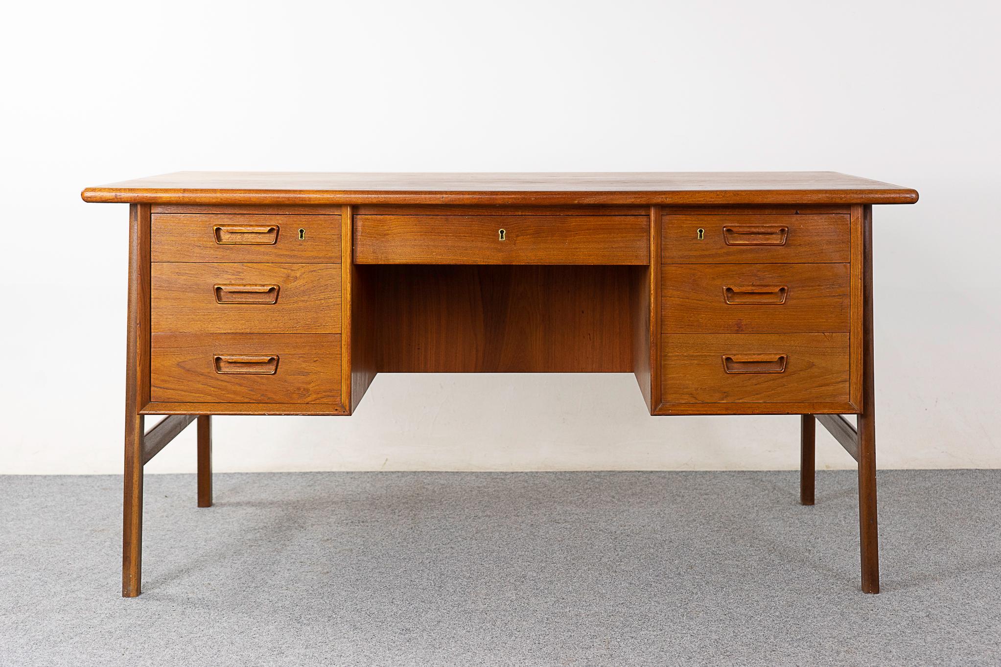 Teak Danish desk, circa 1960's. Robust work surface! Finished on both sides, if placed in the center of a room, it will look fantastic from every angle. Back side has a charming drop down bar with etched glass mirror and a built in bookcase with an