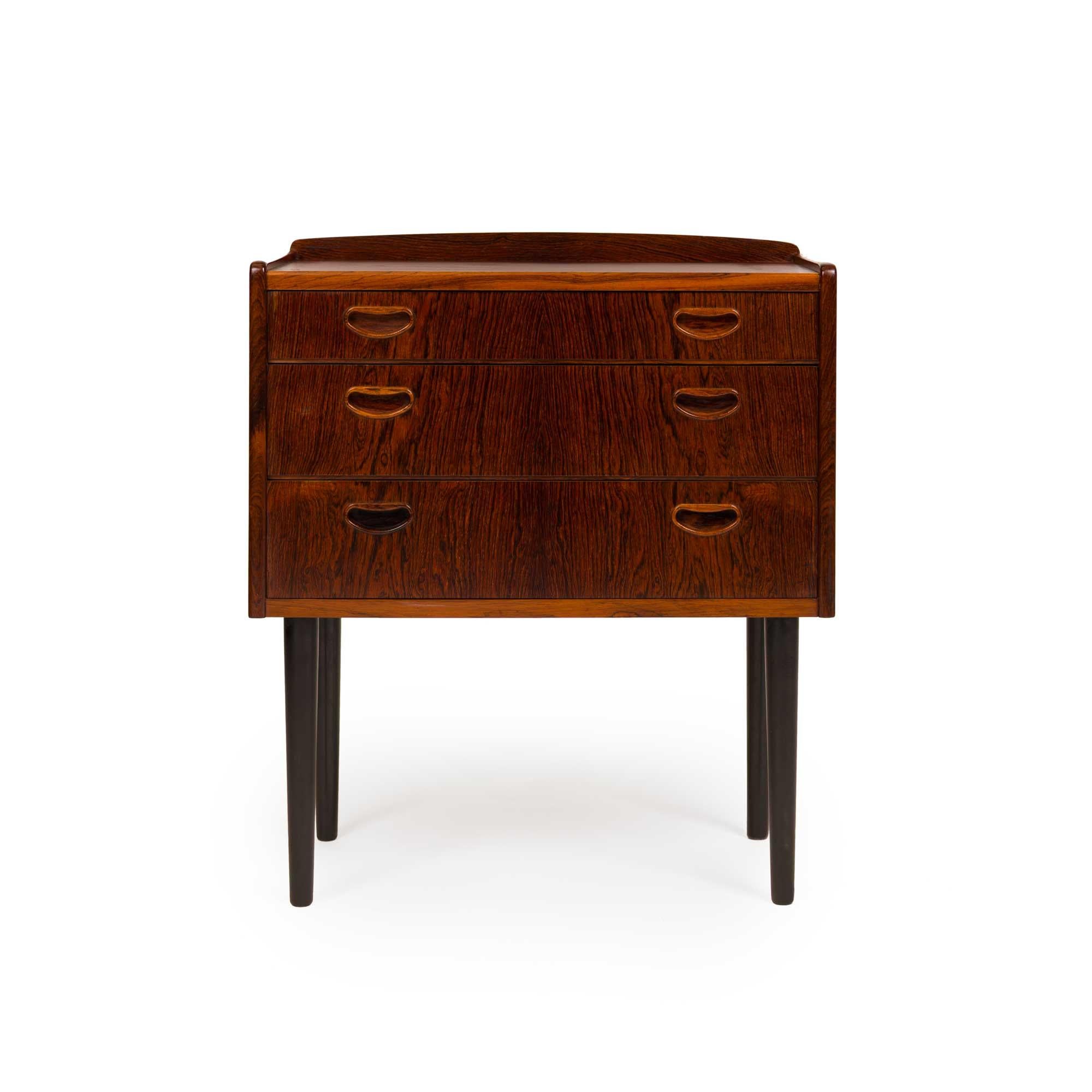 Este baúl danés vintage de palisandro es un impresionante ejemplo de la artesanía moderna de mediados de siglo, y muestra la elegancia y calidad intemporales asociadas al diseño escandinavo. Fabricada con un rico y cálido palisandro, la cómoda