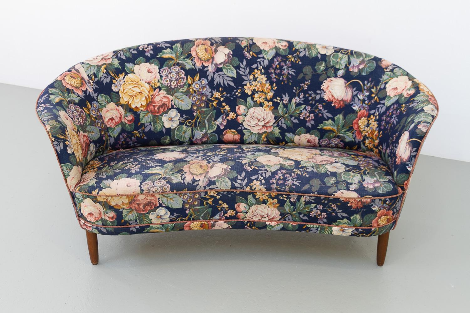 Danish Mid-Century Two Seater Banana Sofa with Floral Fabric, 1950s.

Scandinavian Mid-Century Modern banana shaped sofa with curved armrests, made by Danish cabinetmaker in the early 1950s. 
Four round tapered legs in stained beech. Later