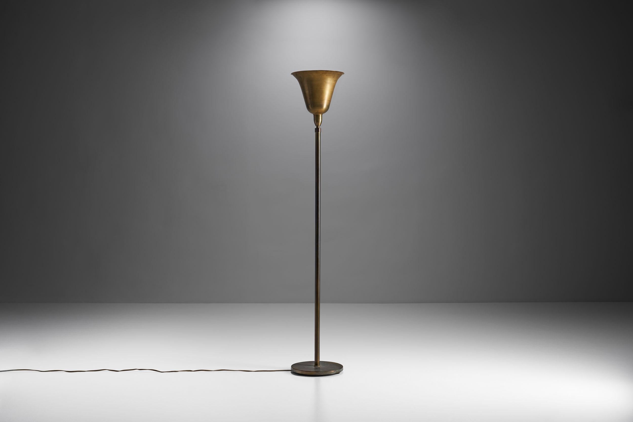 This beautiful midcentury floor lamp combines a classical shape with carefully thought out proportions and Danish craftsmanship.

The head of this lamp resembles the shape of a bell turned upside down, with a Gaussian curve. The brass has a