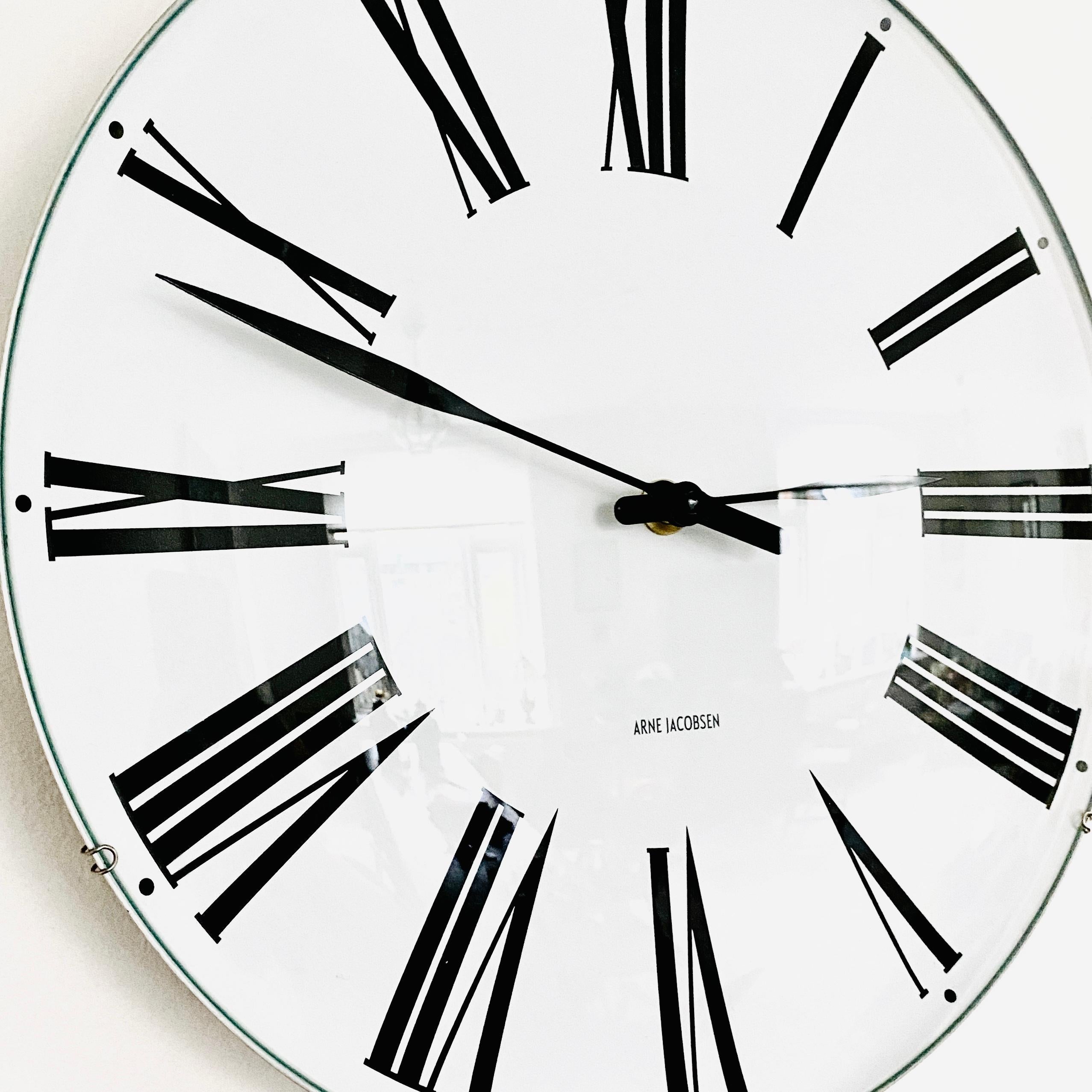 Horloge murale danoise du milieu du siècle par Arne Jacobsen modèle Roma avec horloge à quartz.

Arne Jacobsen pour Rosendahl. Horloge murale en acier avec cadran blanc et chiffres romains noirs, aiguilles des heures et des minutes. Ce modèle mesure