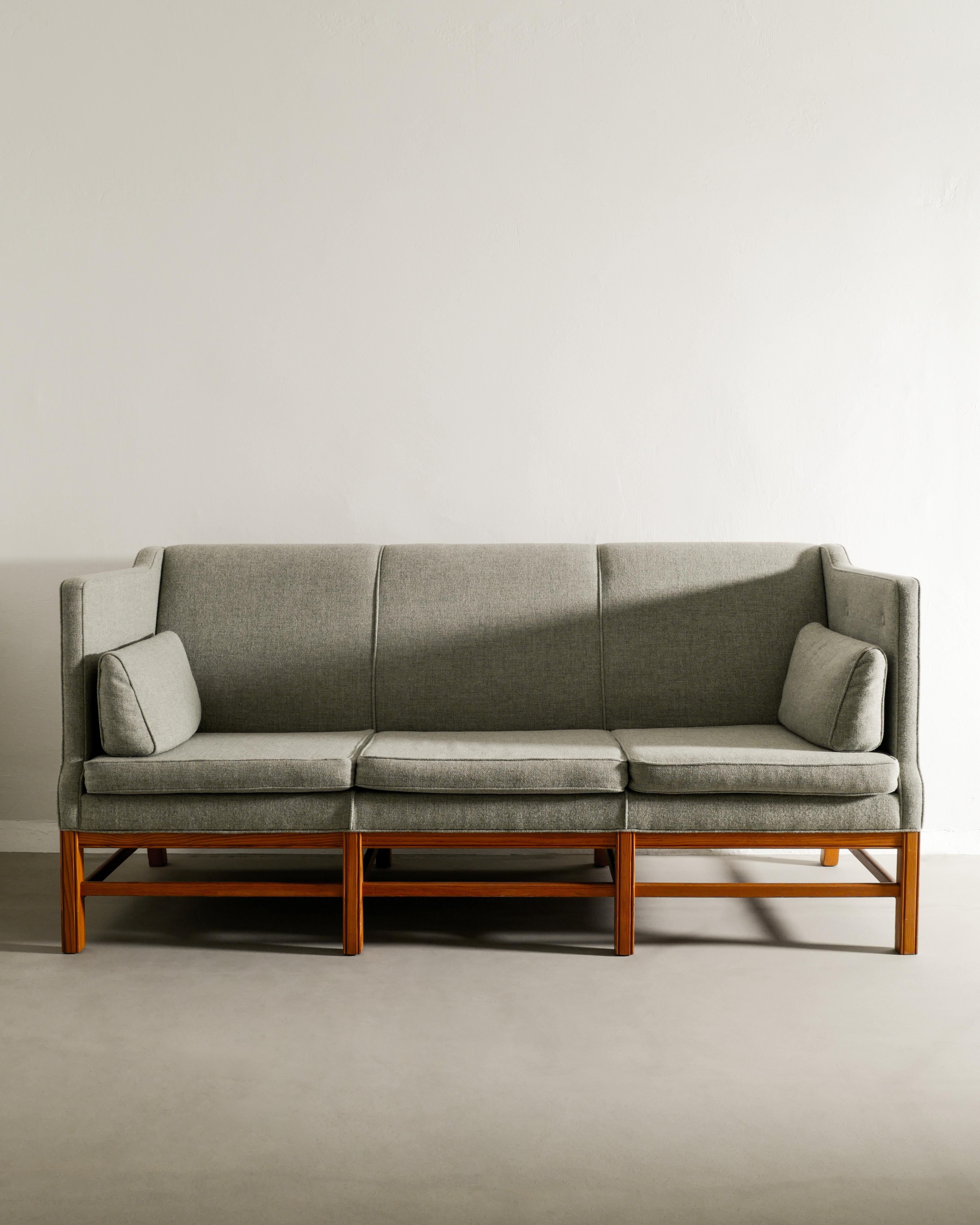Seltenes dänisches skulpturales Dreisitzer-Sofa aus der Mitte des Jahrhunderts mit gebeiztem Kiefernholzgestell und hellgrünem Wollstoffbezug und Kissen, das Kaare Klint zugeschrieben wird, hergestellt in Dänemark, 1950er Jahre. In gutem Zustand mit