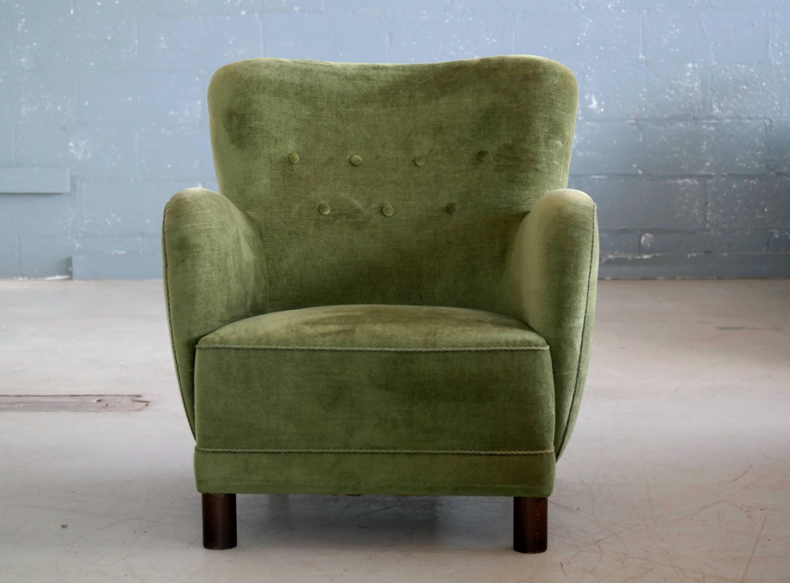 Rare to find Mogens Lassen attributed lounge chair from the 1940s featuring the rounded armrest design and the cylindrical front legs that are very characteristic of Lassen. This chair has been re-upholstered and refurbished at some point in a green