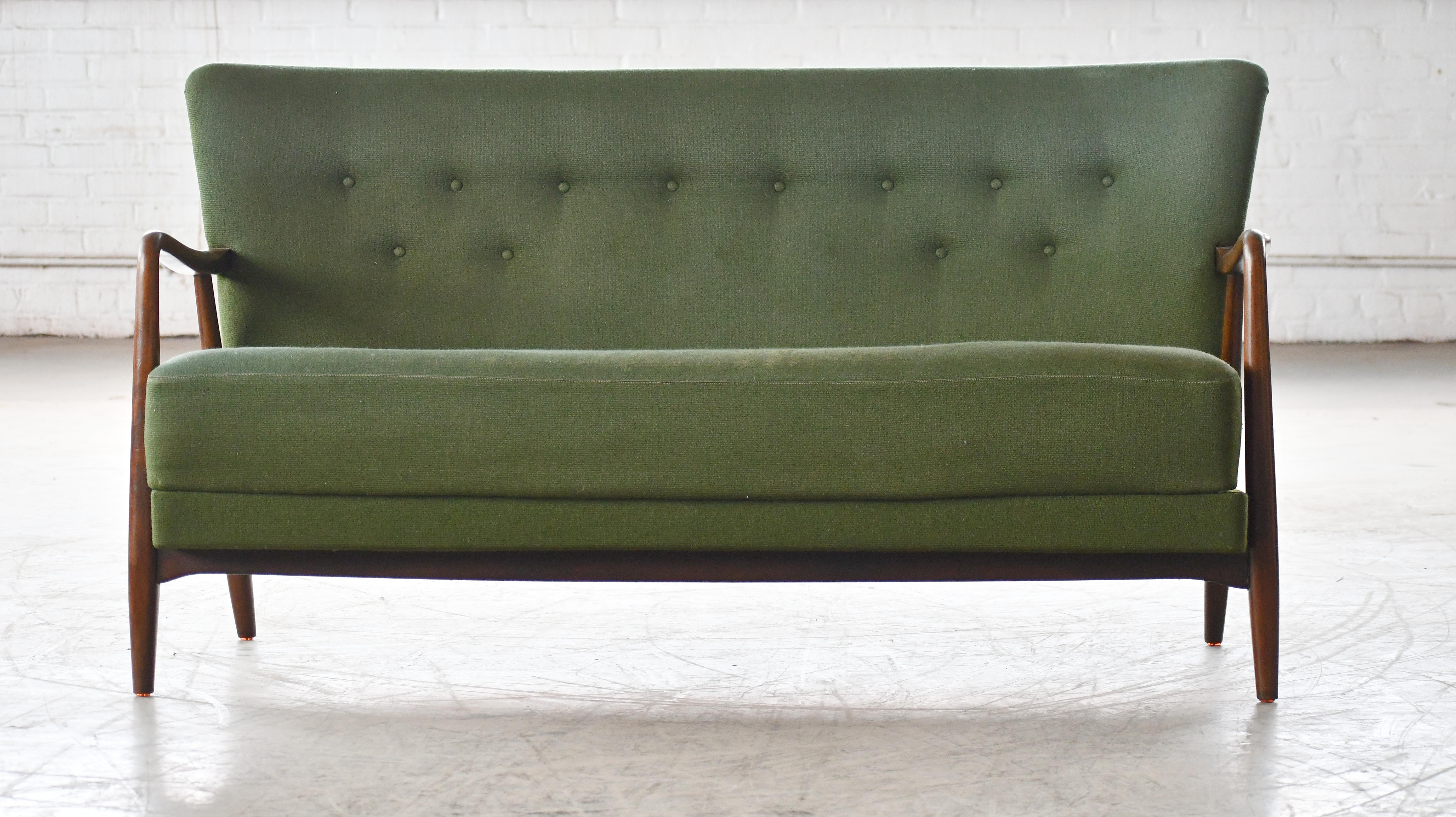 Fantastic 1940s Alfred Christensen designed sofa in his characteristic style of open armrests carved from solid beech wood and made by Slagelse Mobelvaerk in the 1940s. Beautiful refined lines with curving arms that extend into the front leg. Coil