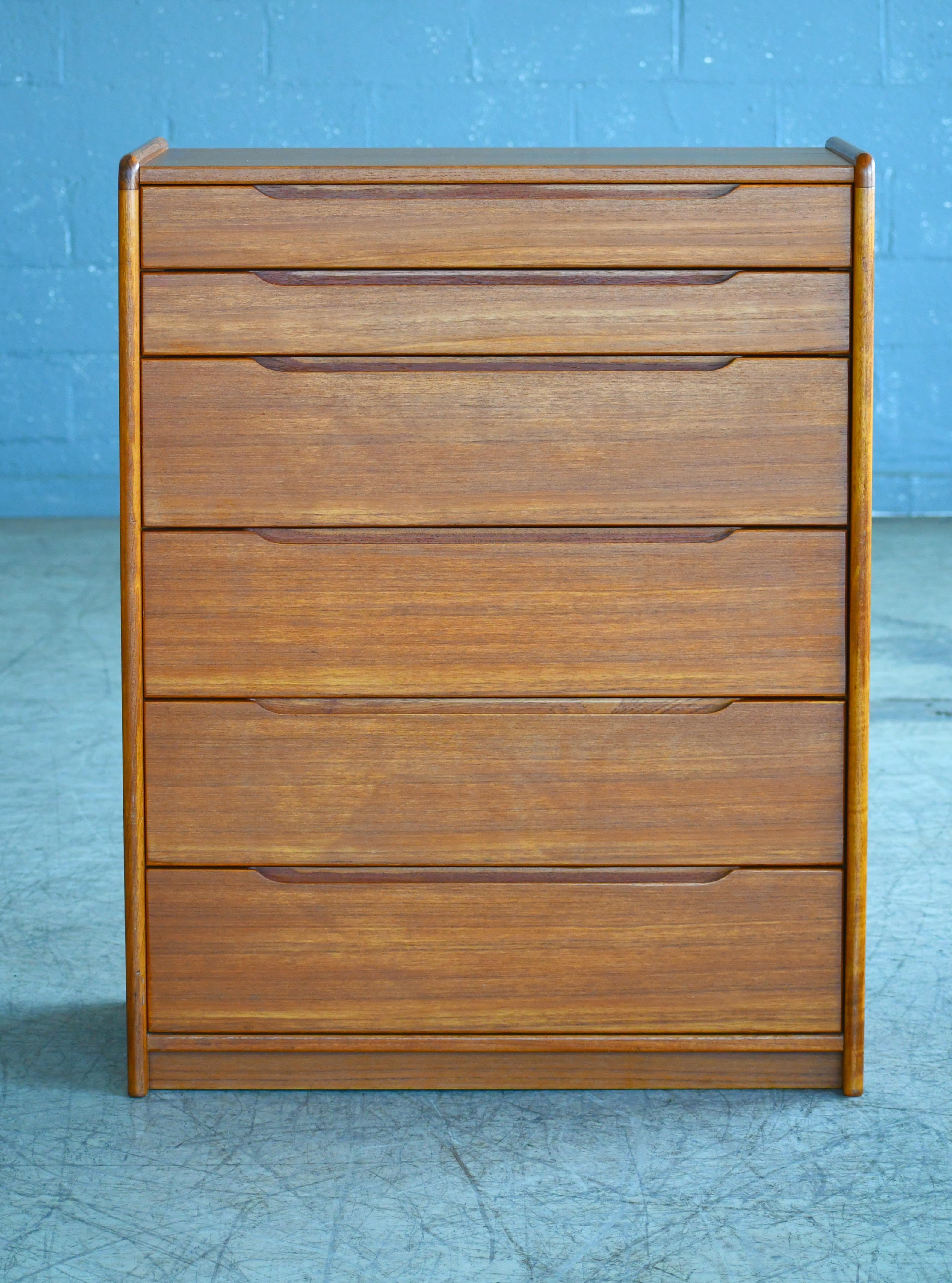 Beautiful Danish 1960s teak tall dresser or chest or drawers. Sharp distinct design lines and very high build quality. Teak veneer with great grain and color and edges of thick solid teak overall very good condition with only very minor age