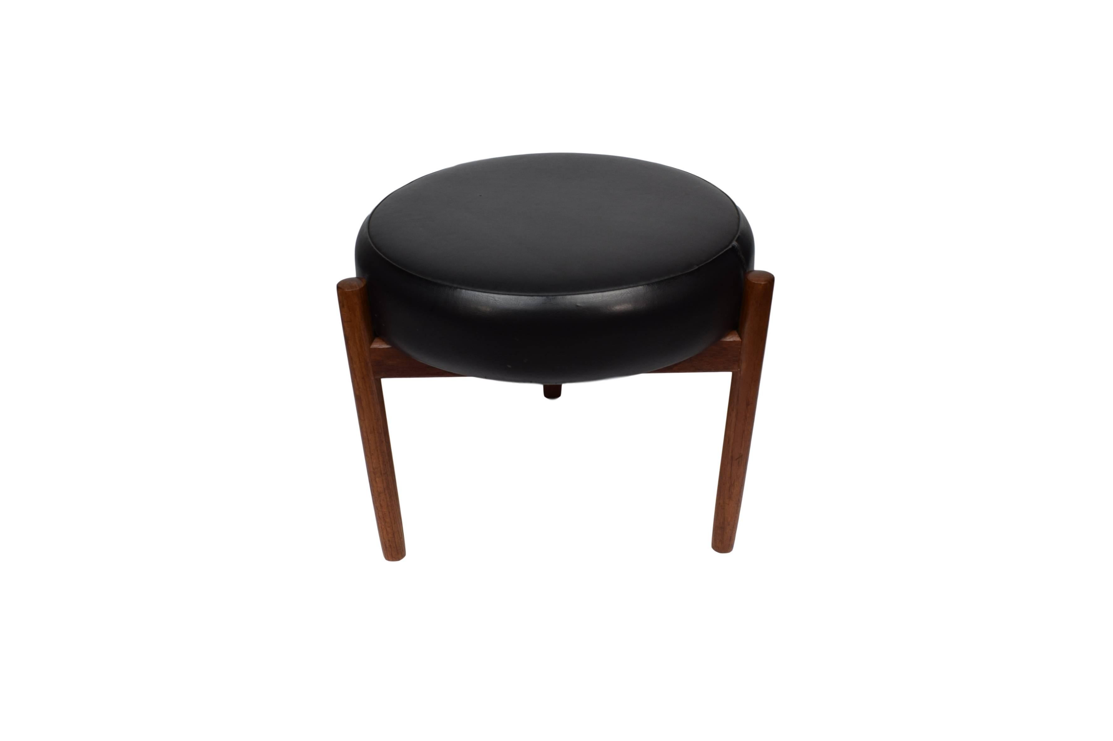 A Danish midcentury teak ottoman by Hugo Frandsen. Produced by Spøttrup. The ottoman is upholstered with black imitated leather.


