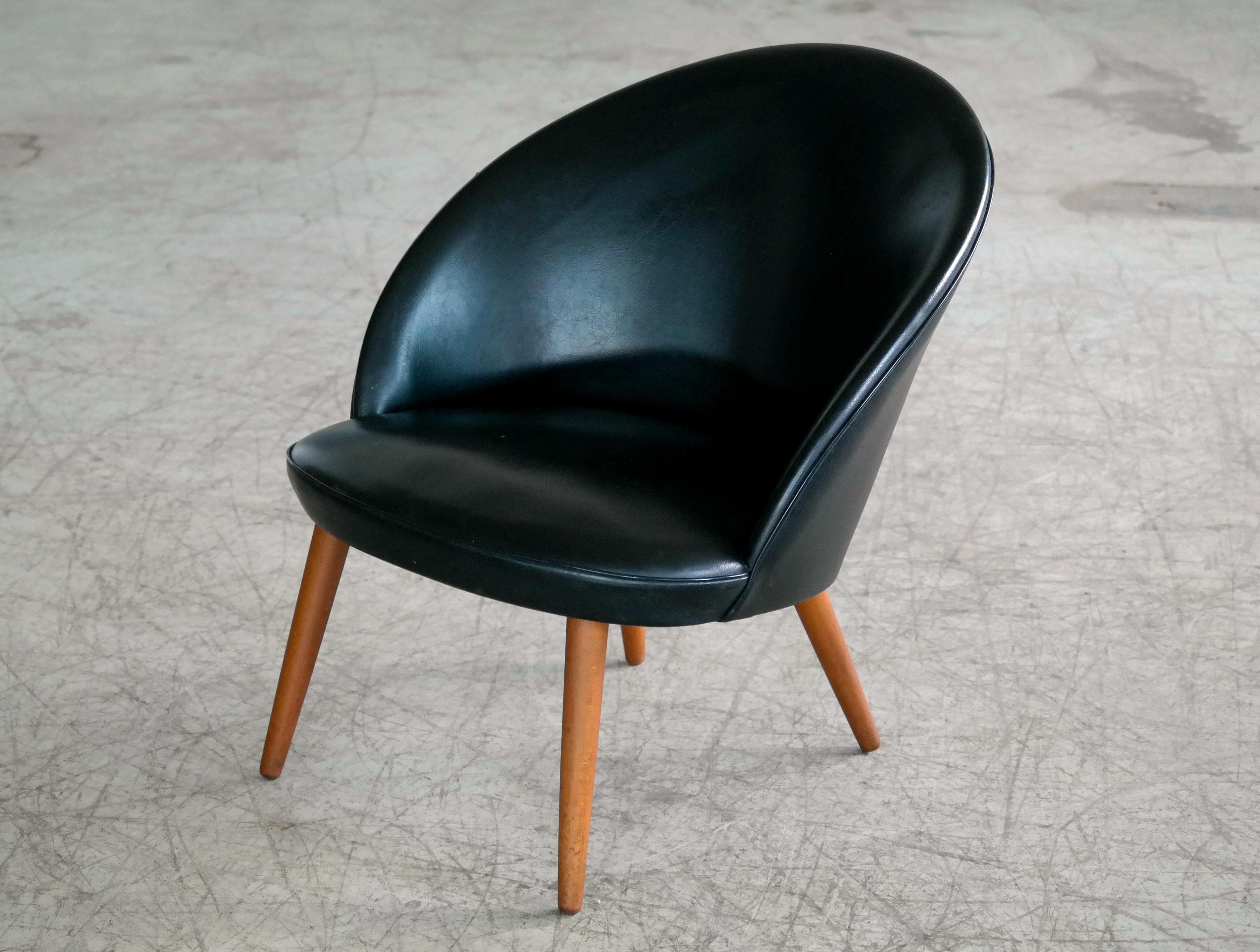 Classic small easy chair in black vinyl with curved back and legs in solid beech designed by Ejvind A. Johansson in 1958 as model 301 for Gotfred H. Petersen. Mr. Johansson is known for many of his Classic designs many of which were made during his