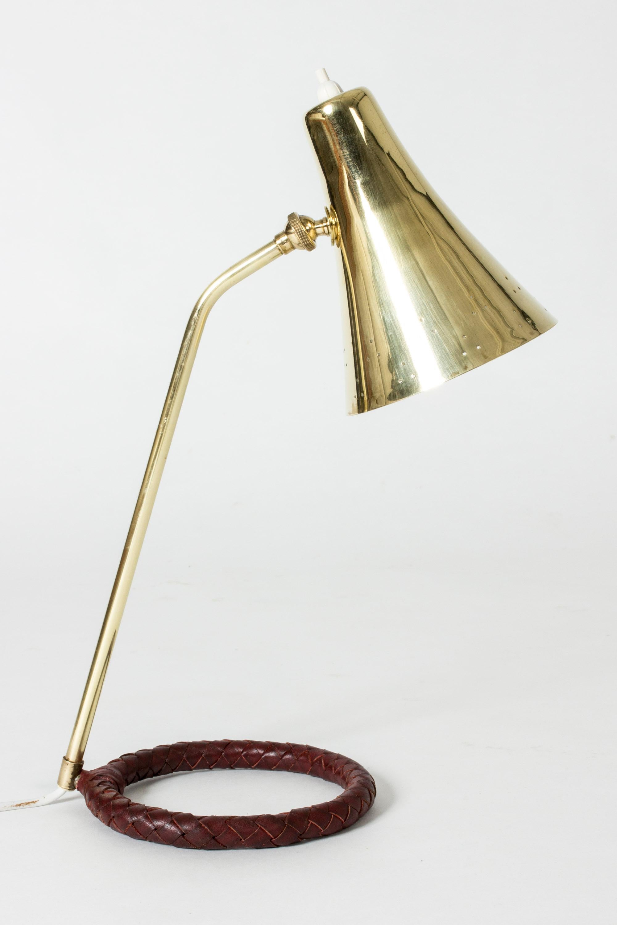 Elegant Danish midcentury brass table or desk lamp with a cool round base. Shade perforated with small decorative holes around the rim, base with wreathed brown leather.