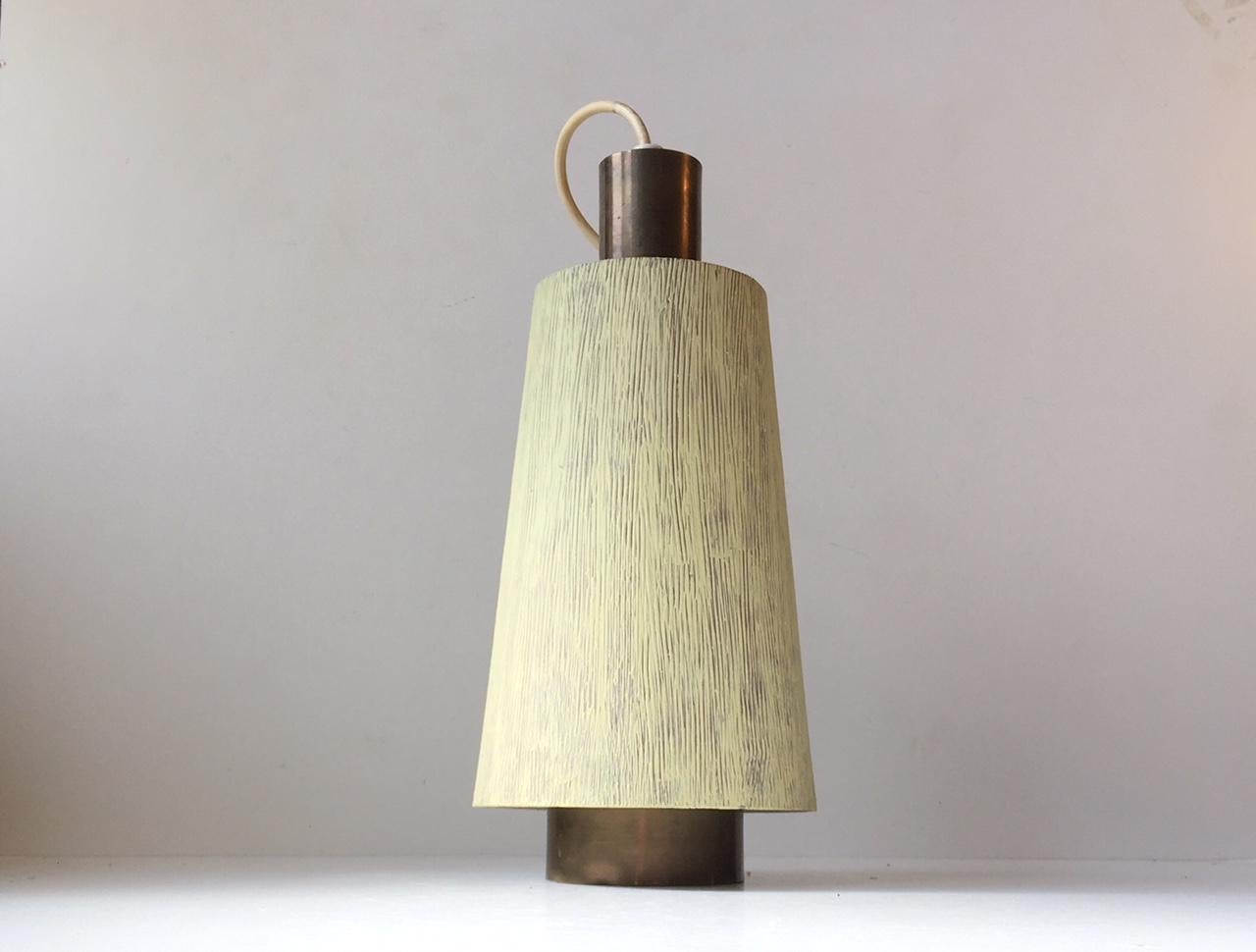 This vintage pendant light is made from solid brass and decorated with a textured light green/yellow paint to the external shade. It was manufactured by Lyfa and is in the style of Paavo Tynell and Lisa Johansson-Pape. Measurements: H: 32, Diameter:
