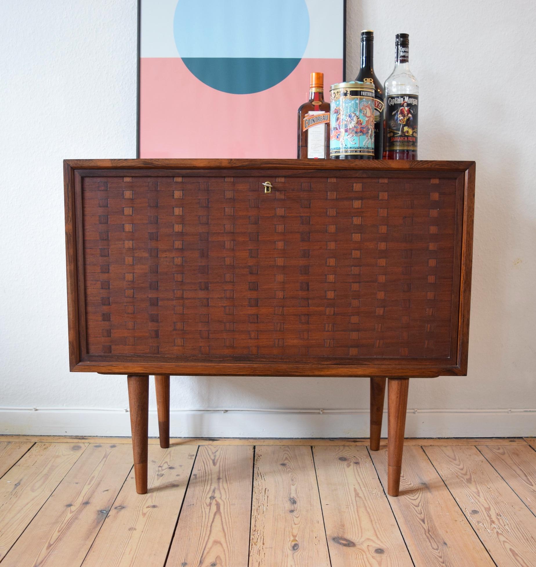 Modernist Brazilian rosewood Poul Cadovius Cado Bar cabinet with fold-down door 
Designed by Poul Cadovius - Produced by System Cado - Model Cado - Year of design 1965

Very elegant and practical rosewood cabinet with fold-down door. Features