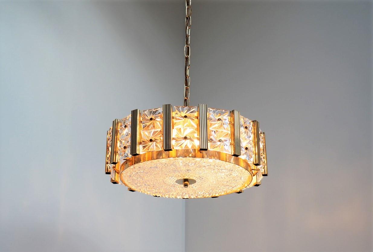 Beautiful gold colored chandelier decorated with square crystal glass pieces and is made in the 1960s by the Danish company Vitrika with glass from the Swedish glass manufacturer Orrefors.

The chandelier gives a nice and cozy illumination and the