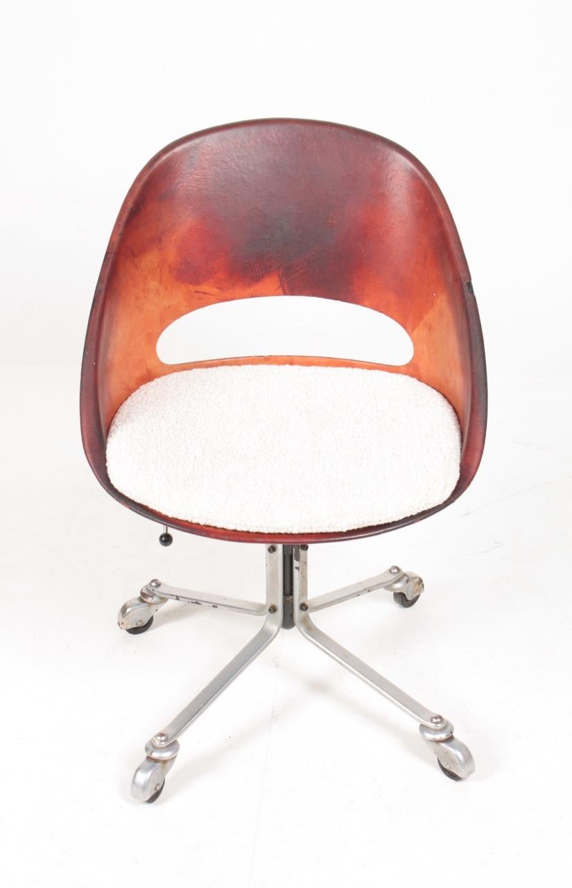 Swivel chair in patinated leather and bouclé on a swivel base. Designed by made in Denmark. Original condition.