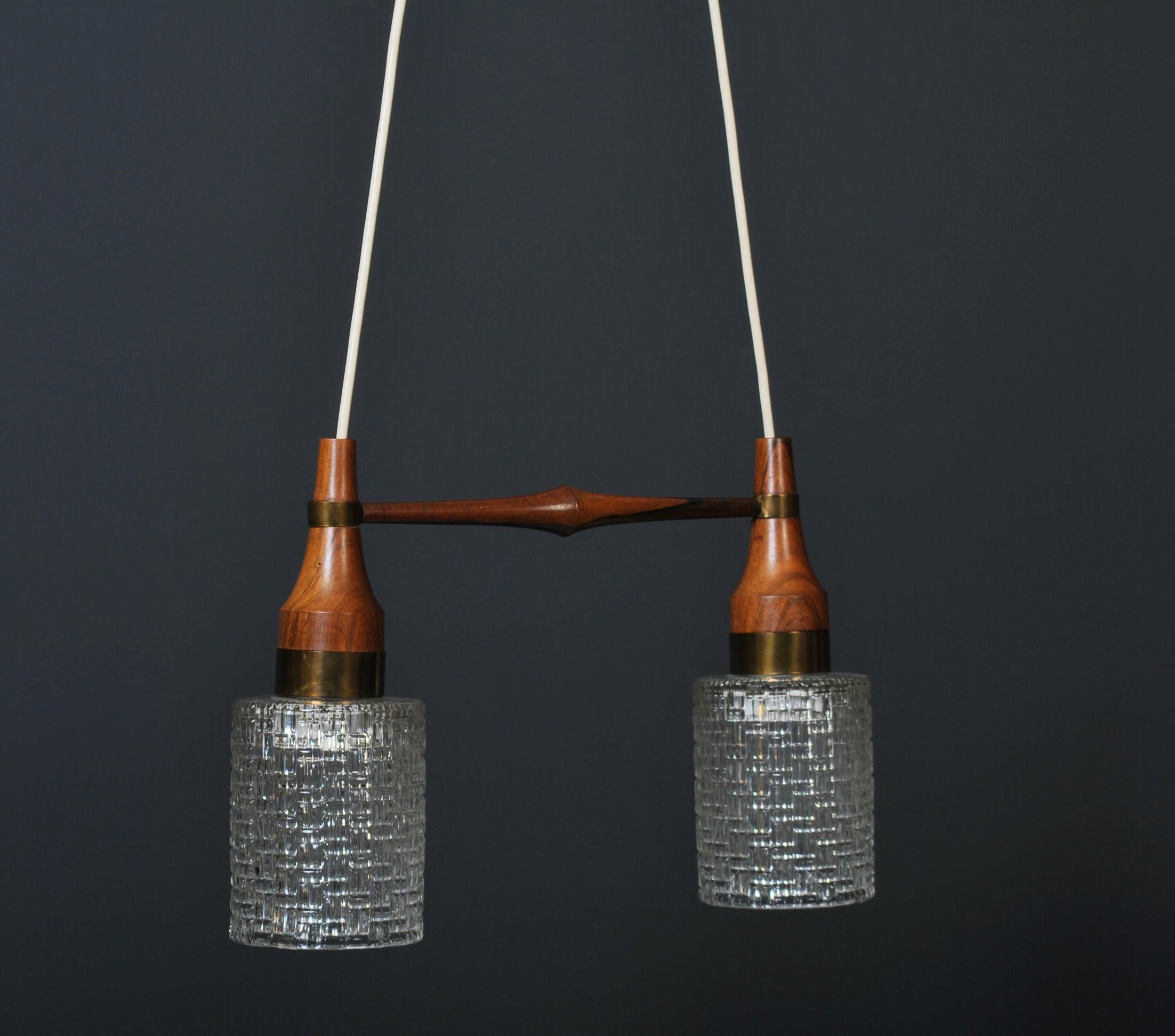 Beautifully designed and constructed Danish midcentury dual pendant light, circa 1950’s. Brass with cut glass shades. Current drop length is 110cm but can be simply adjusted to requirements.