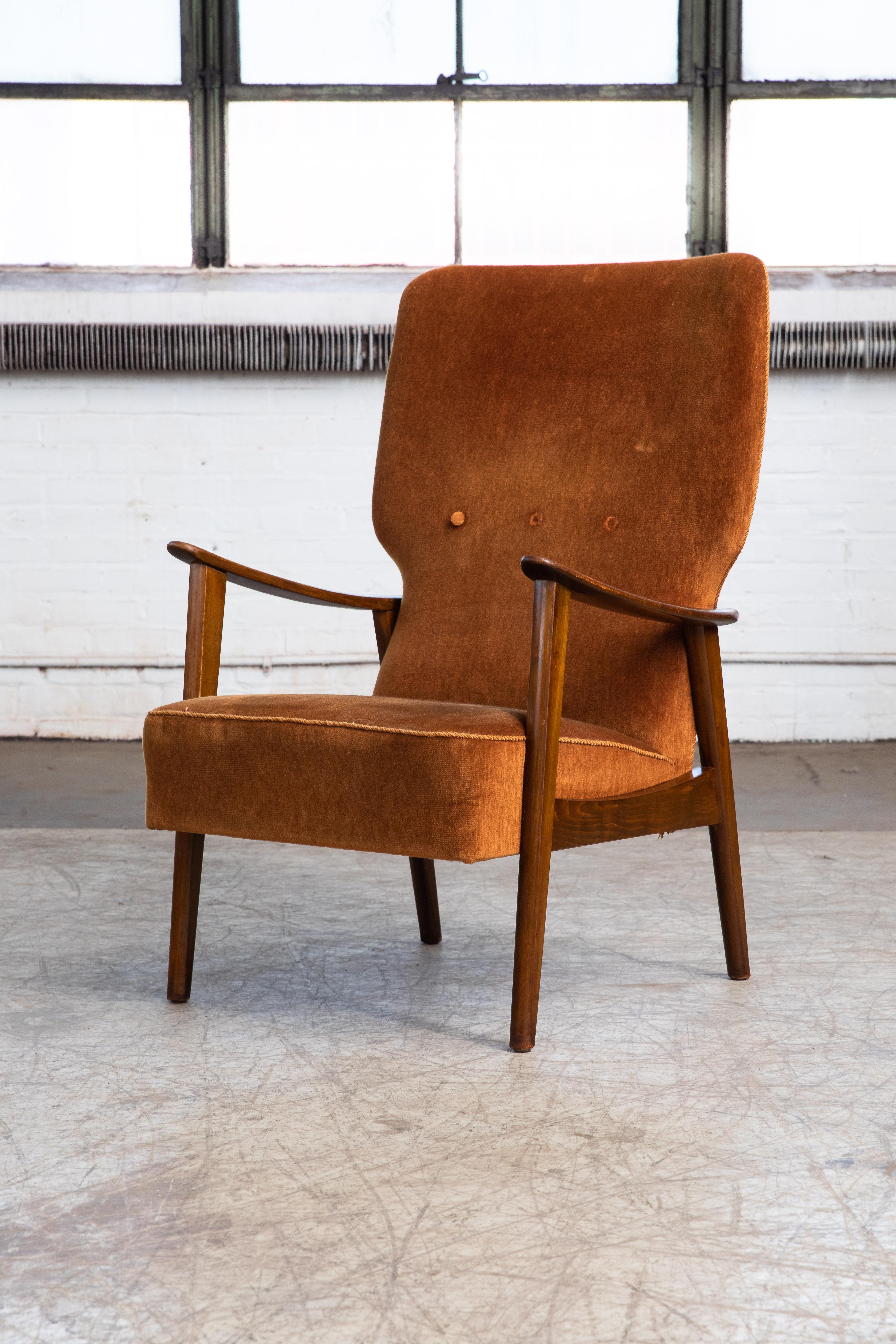 Stylish 1950's easy chair by Fritz Hansen from the early 1950's. Similar in style to some of hans Wegner's designs and also reminiscent of some of Arne Vodder's typical designs with the slight curvature to the armrests. Made from solid oak stained