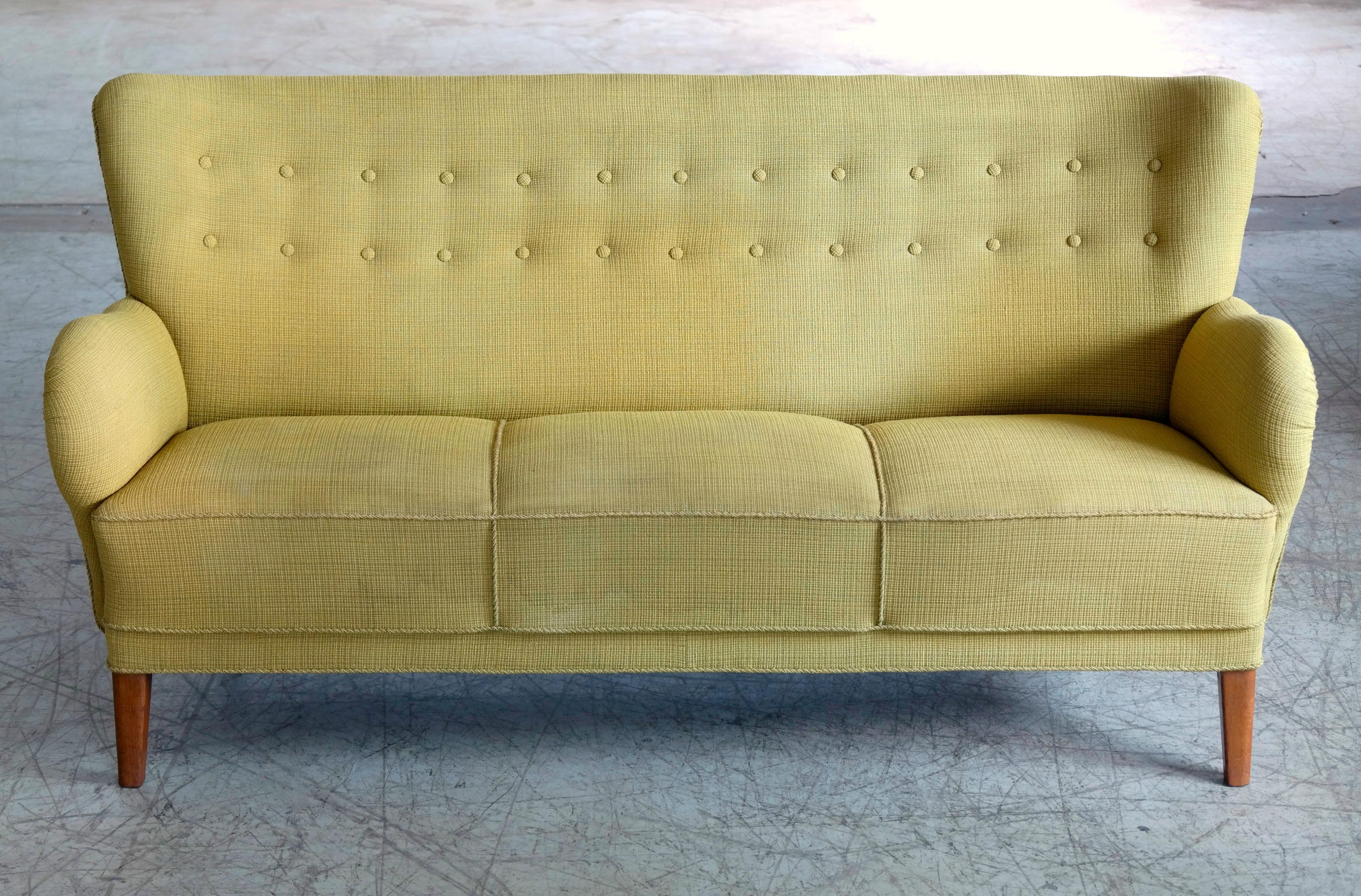 Fantastic 1940s three-seat sofa in the style of Flemming Lassen. We don't know the maker and designer of this sofa but the style is very much similar some of Flemming Lassen's sofa designs made by AJ Iversen. Especially the legs and the armrest are