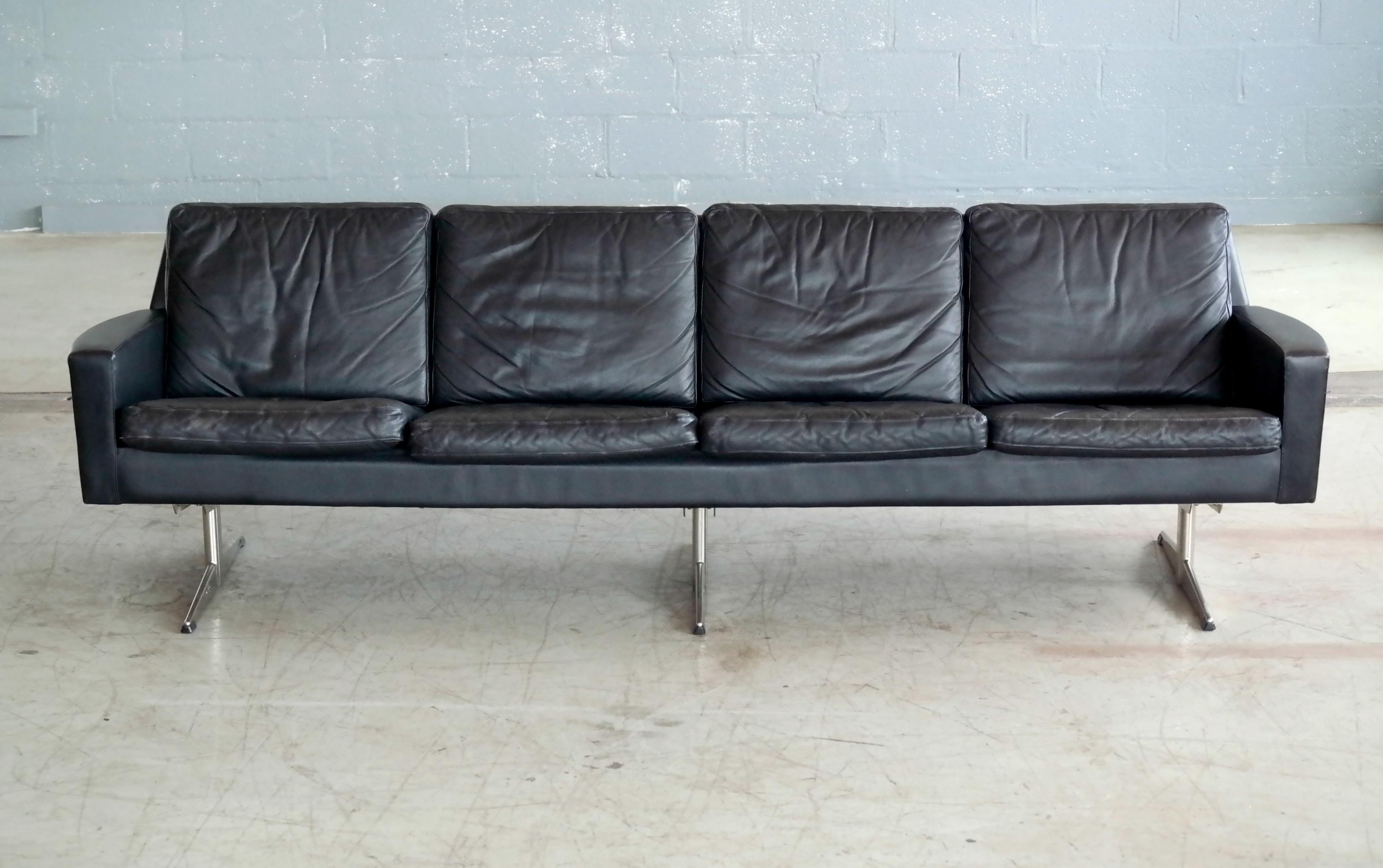 Great Danish 1960s four-seat airport sofa in black leather on steel legs. With clear design parallels to Arne Jacobsen and Hans Wegner's famous airport sofas the piece appears to be the work of Designer Georg Thams and Vejen Polstermobelfabrik,
