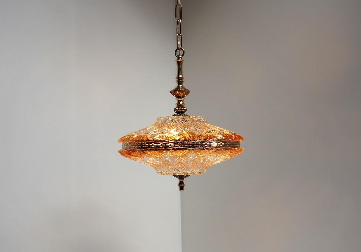 Chandelier with 2 big glass shades - one on the top and one at the bottom. In the middle it has a decorative belt made of brass as well as the top is solid brass. It is made by the Danish company J. Sommer ApS in the 1950s.

The light is being