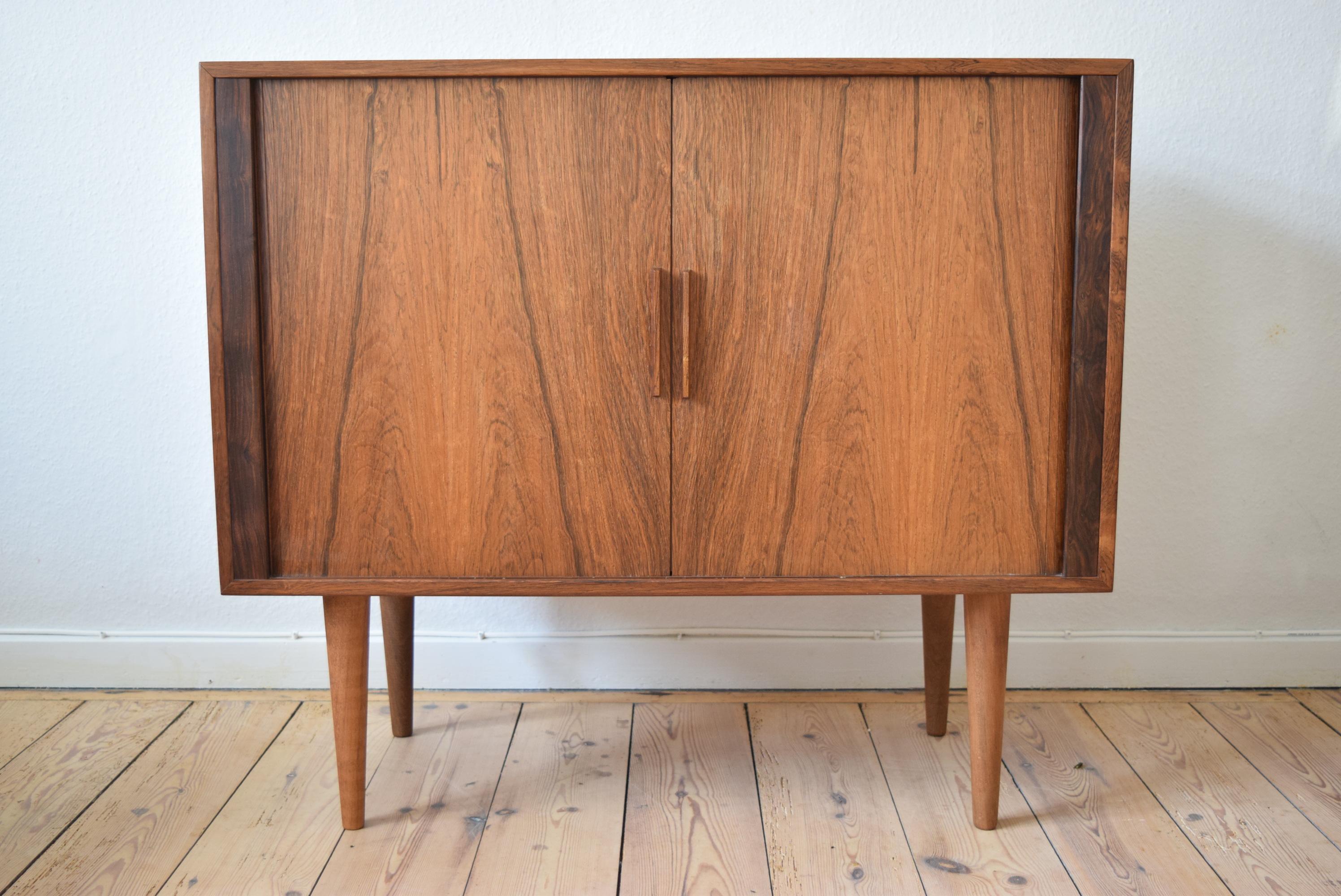 Danish rosewood record player cabinet by Kai Kristiansen for FM Møbler. Manufactured in the 1960s, this piece features two tambour doors with internal shelving space for LP records and lower section for media devices. Striking rosewood grain