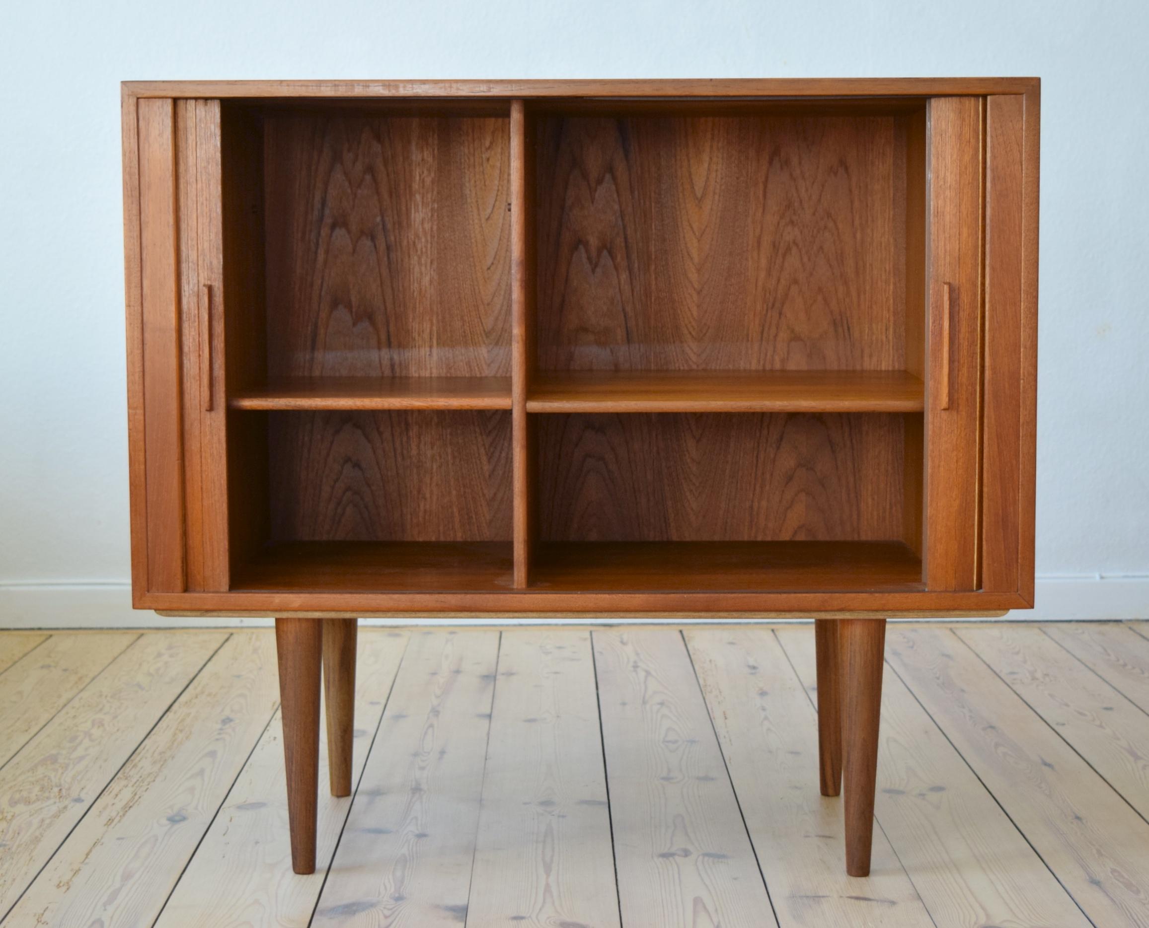Danish teak cabinet by Kai Kristiansen for FM Møbler. Manufactured in the 1960s, this piece features two tambour doors with solid teak handles. Two internal compartments with adjustable shelves on each side. We have more of these cabinets available