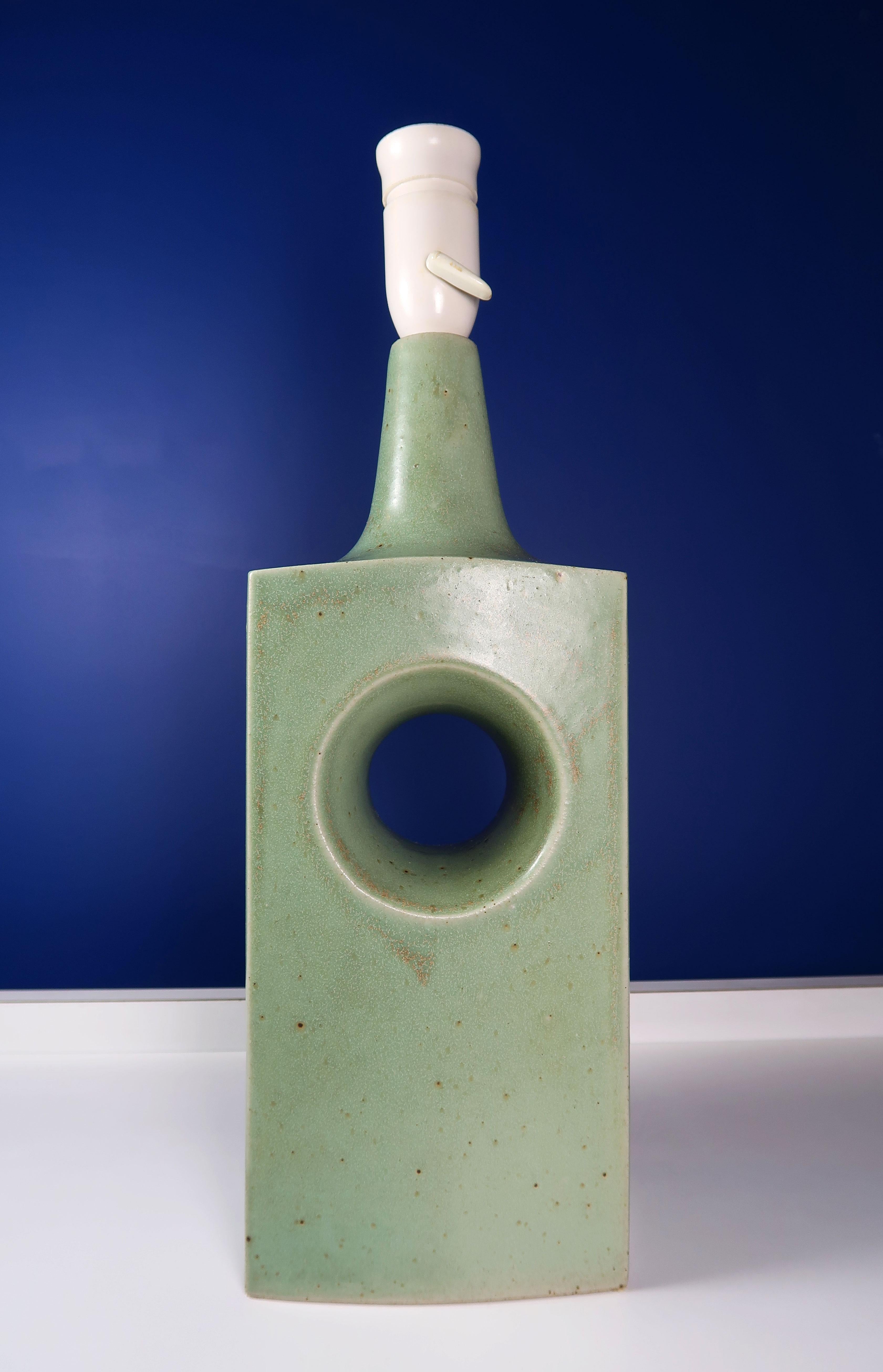 Beautiful light green Danish Mid-Century Modern glazed stoneware table lamp manufactured by Knabstrup Keramiske Industri in the 1960s. Sage green glaze with golden brown nuances on tall rectangular shaped lamp with circular hole in the center.