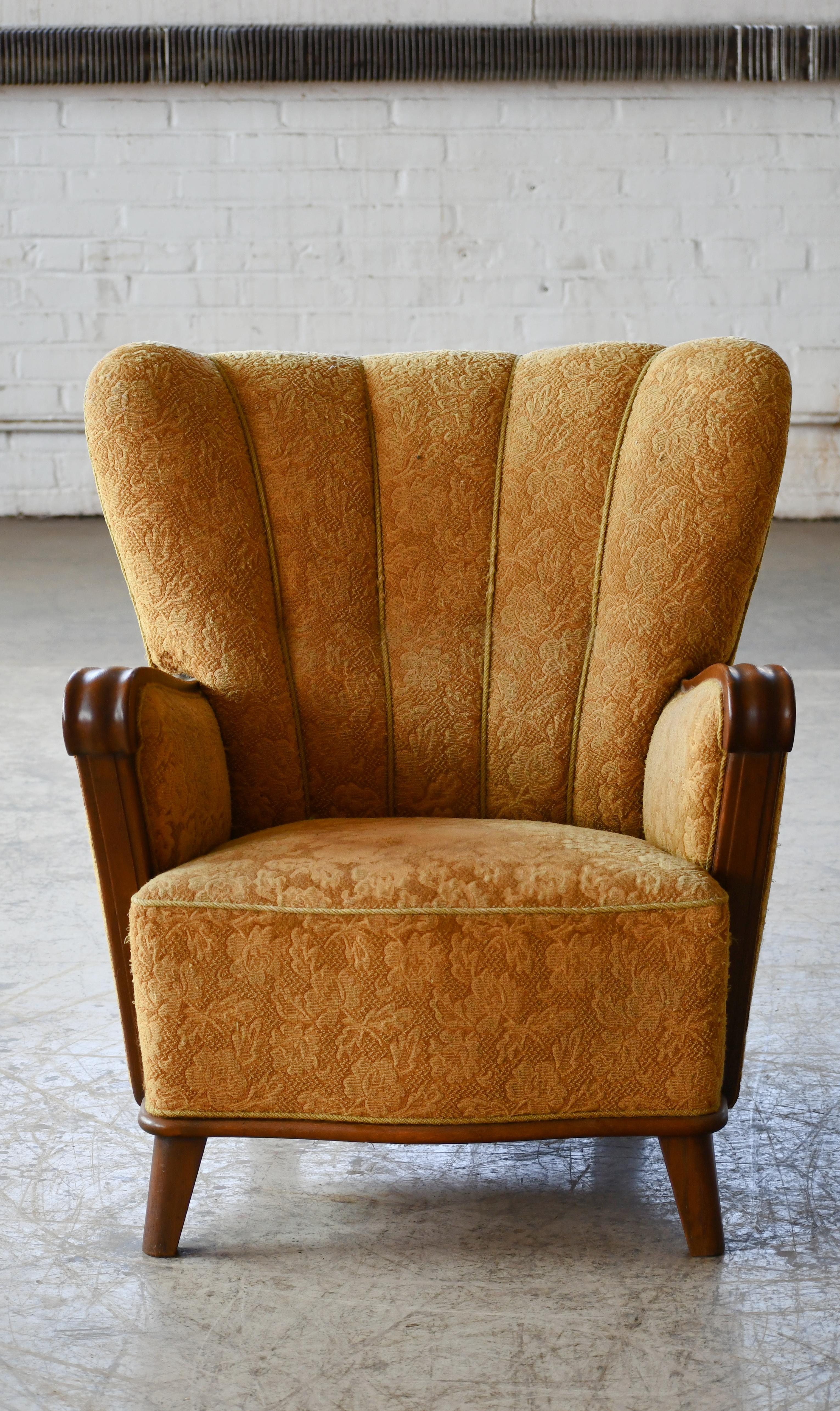Exceptional ultra cool and comfortable mid-size Art Deco lounge chair made in Denmark probably around mid 1930's to early 1940's. Very rare find. We love the stance, scalloped backrests and carved wooden armrests. The chair has a very nice size