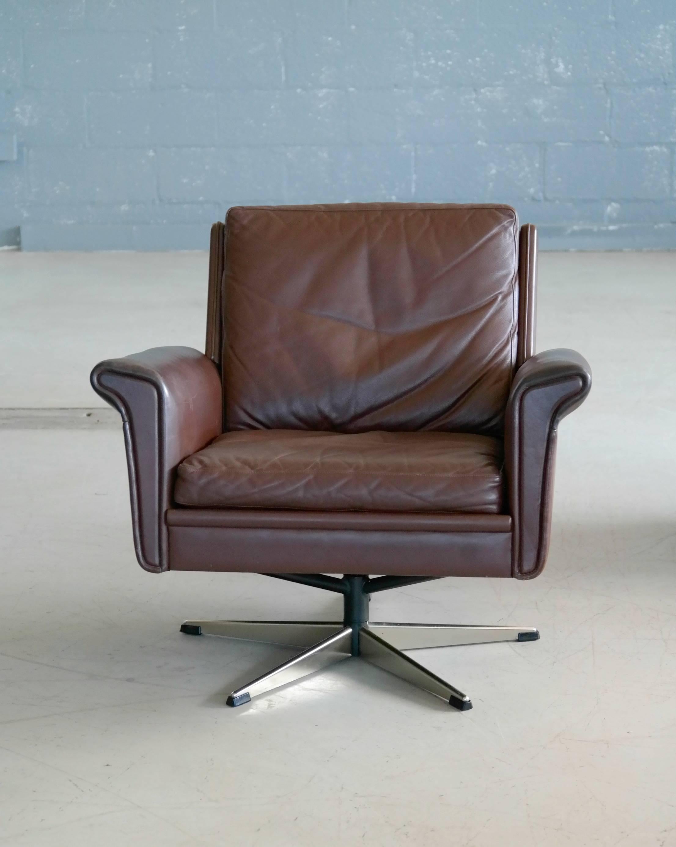 Fabulous modern and luxurious swivel chair in supple brown chocolate colored leather on a chrome-plated aluminium swivel base. Beautiful example of Danish modern at its best designed by Georg Thams, circa 1969 and produced sometimes in the early