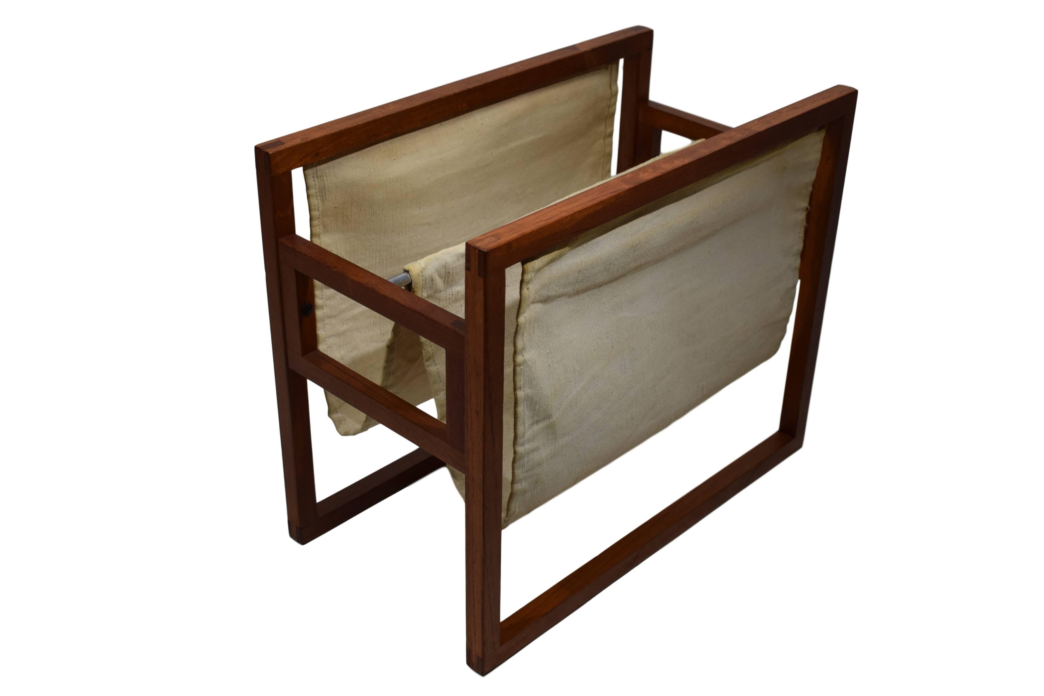 A Danish midcentury magazine rack by Kai Kristiansen. The magazine rack has a teak frame with finger joints and dual canvas slings.