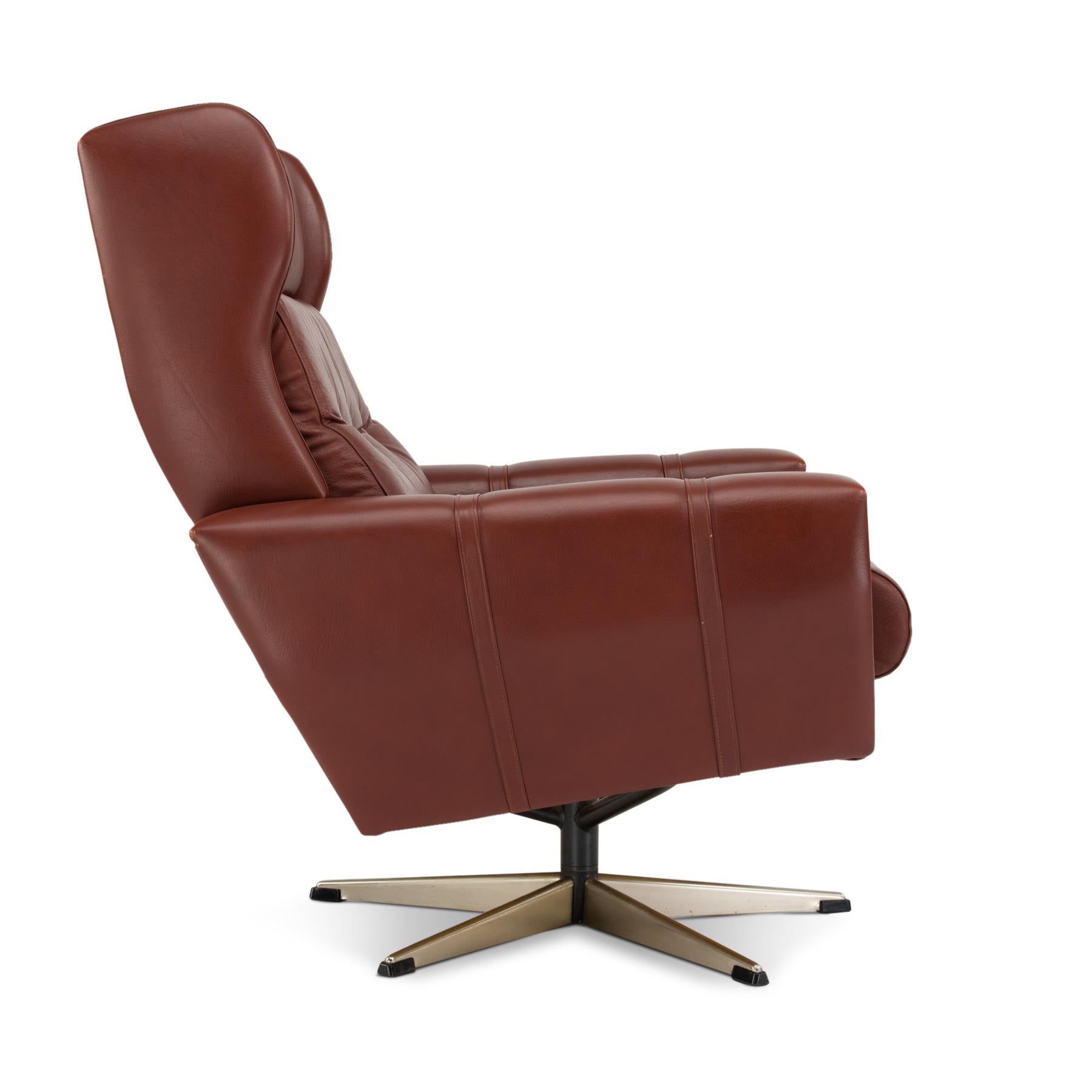 This brown leather swivel chair is made under brand name Lystolet by furniture factory Lystager Industri in Hornslet Denmark in the early 1970s. The chair has a cool look to it probably due to the straight up shaping and reddish brown buttoned