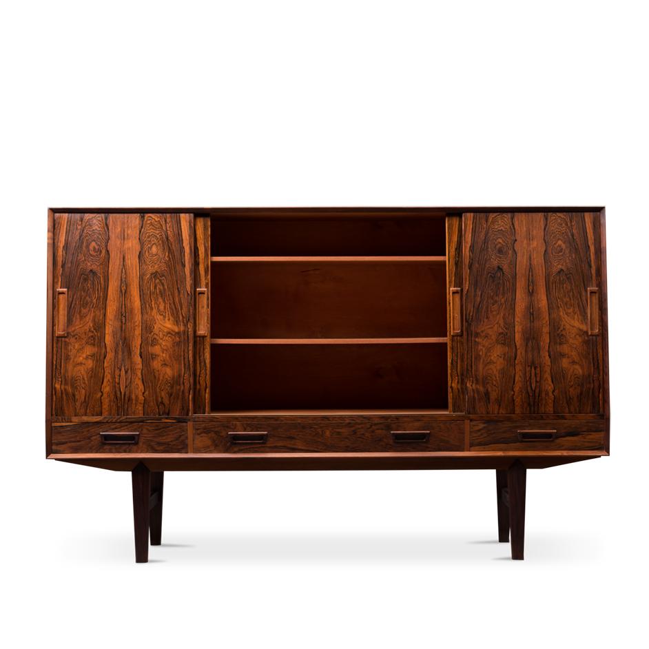 Strong patterned dark wood has been used on this credenza. It is what we call a high board credenza and comes with a myriad of storage spaces and mirror equipped liquor bar. The print of the wood is carefully transponded on all sliding doors, and