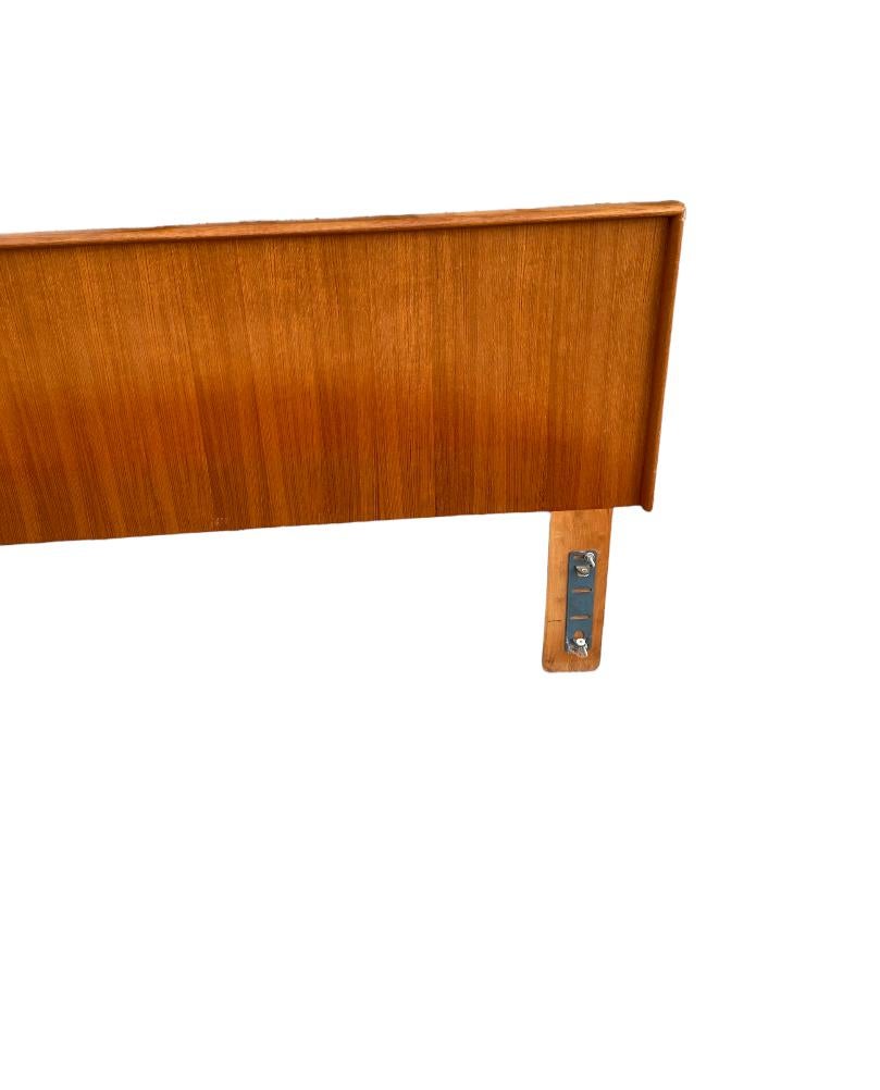 Simple and elegant Mid-Century Modern headboard. Made in Denmark and executed in lustrous colorful teak. Classic Danish styling and lines. In good condition with original mounting hardware included. The lower portion is slightly darker because it