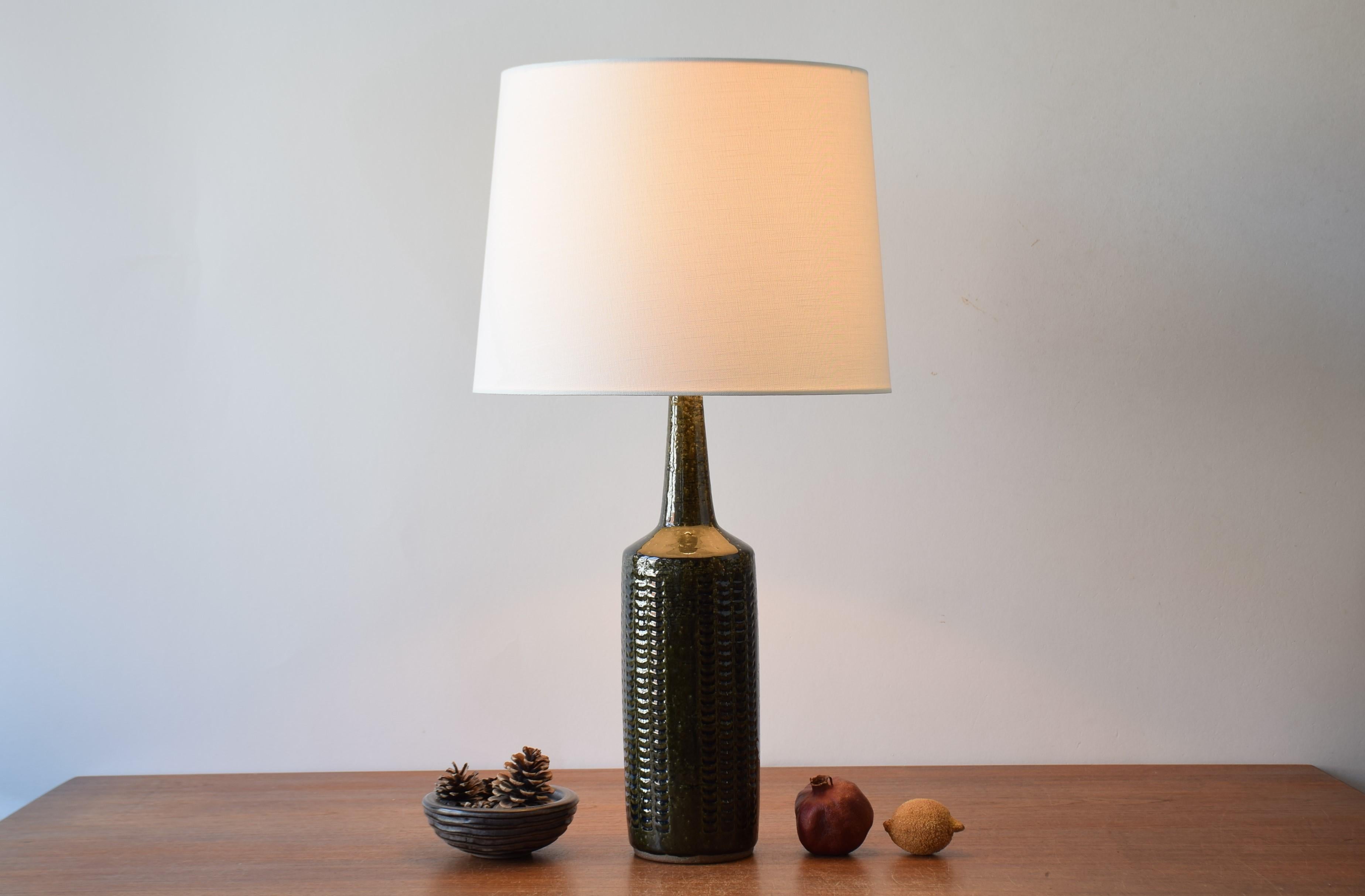 Danish midcentury table lamp from Palshus.
The lamp was designed by Per Linnemann-Schmidt and manufactured circa 1960s.
It has a dark green glaze with blue accents on a wave like decor and is made with chamotte clay which gives a rough and vivid