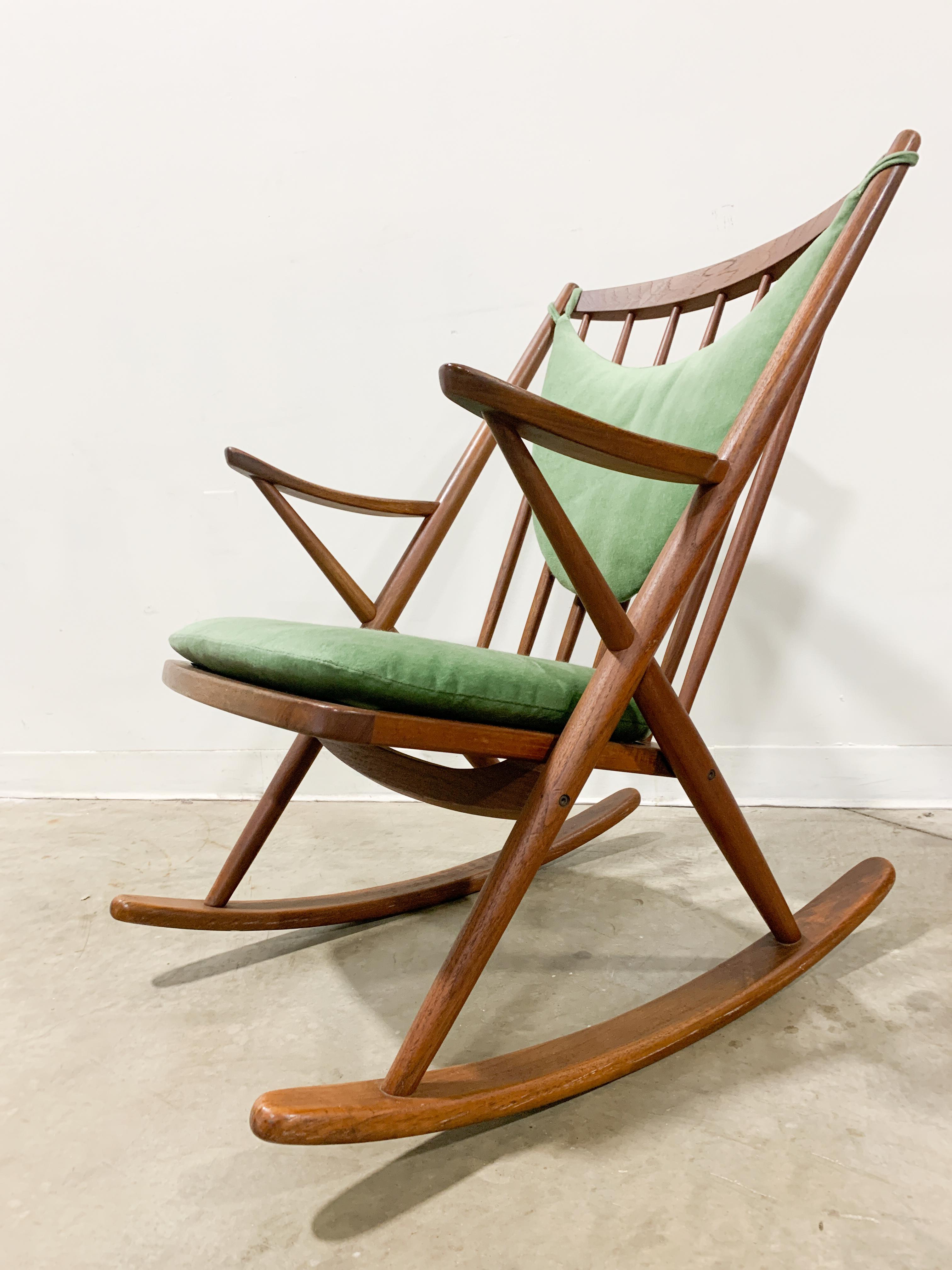 Beautful solid teak rocker designed by Frank Reenskaug for Bramin of Denmark. Very comfortable chair with a velevet seat cushion over rubber straps and a crescent shaped back cushion for an extra level or relaxation. Frame is very solid and cushions