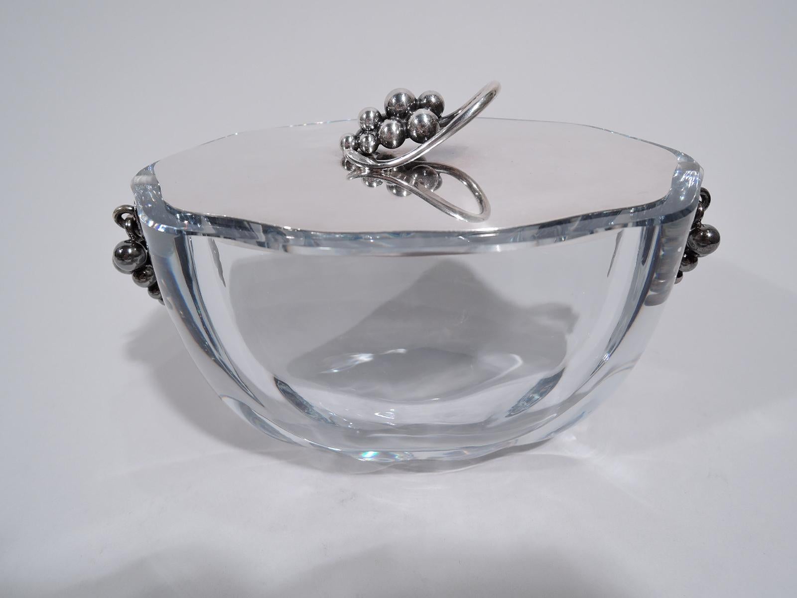 Mid-Century Modern jar. Made by E. Dragsted in Denmark. Thick and ovoid clear glass bowl with sterling silver grape bunches loose-mounted to ends. Flat sterling silver cover with grape bunch finial. Beautiful Jensen-inspired design. Cover fully