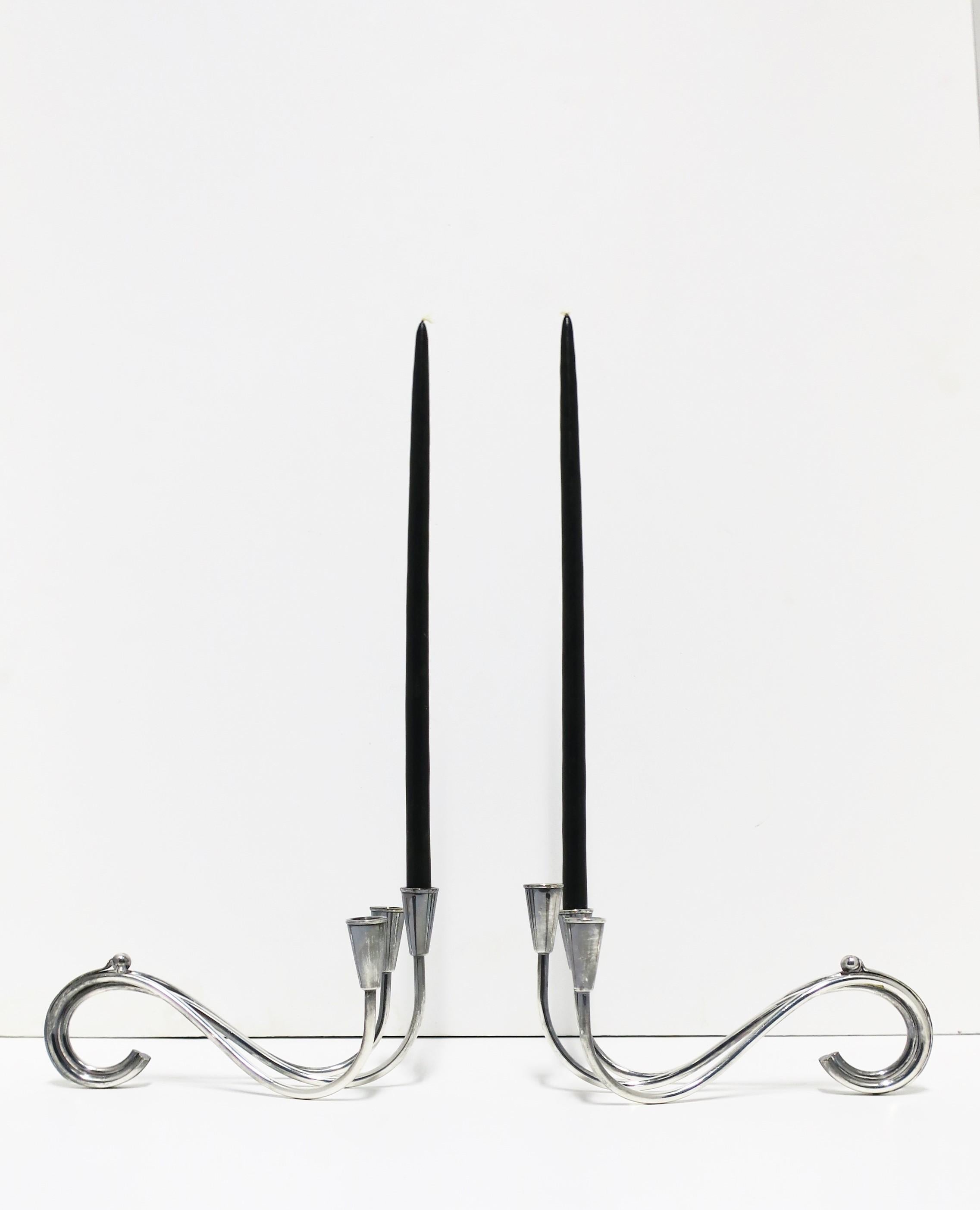 A beautiful pair of Danish Midcentury Modern sterling silver plate candlestick holders/candelabras by designer Carl Frederik Christiansen, circa mid-20th century, Denmark. Both are marked with designers' initials 