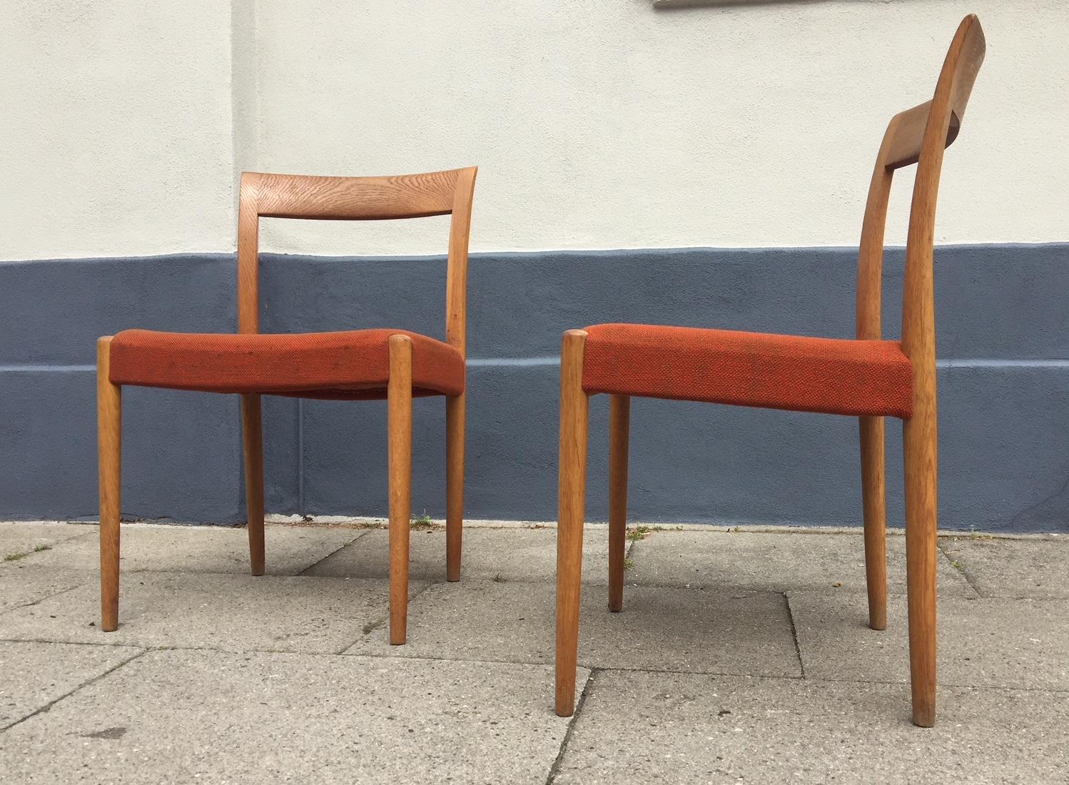 A set of two oak chairs with original orange wool upholstery. They were manufactured and designed by Søren Willadsen in Denmark in the late 1950s or early 1960s. Both of them have a brass makers mark beneath the seat. The design may have been