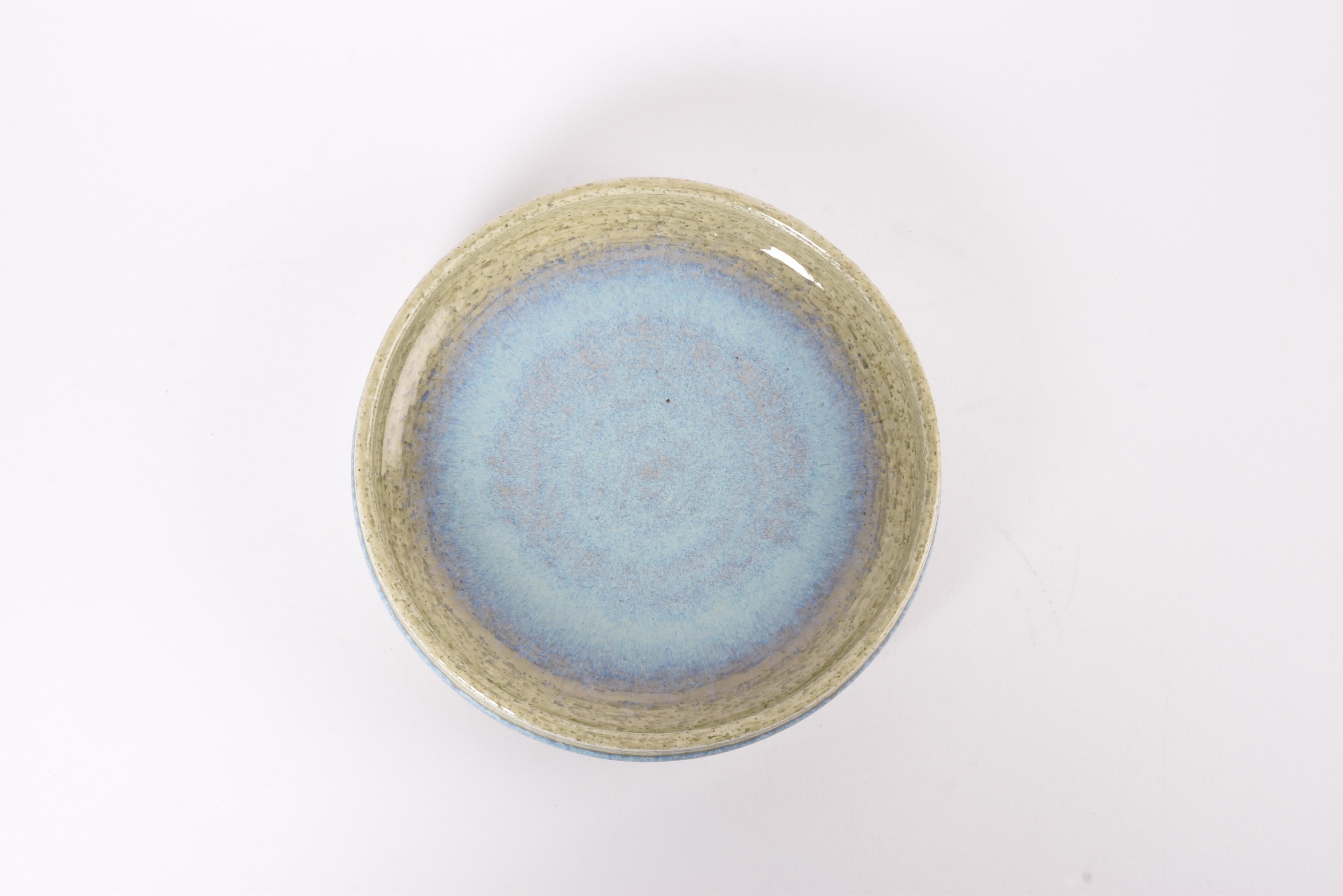 Ciotola bassa in ceramica di Per Linnemann-Schmidt per Palshus, Danimarca. Realizzato negli anni '60.

La ciotola ha una smaltatura di colore verde chiaro e blu chiaro al centro e sul bordo esterno. È realizzato con argilla chamotte che conferisce