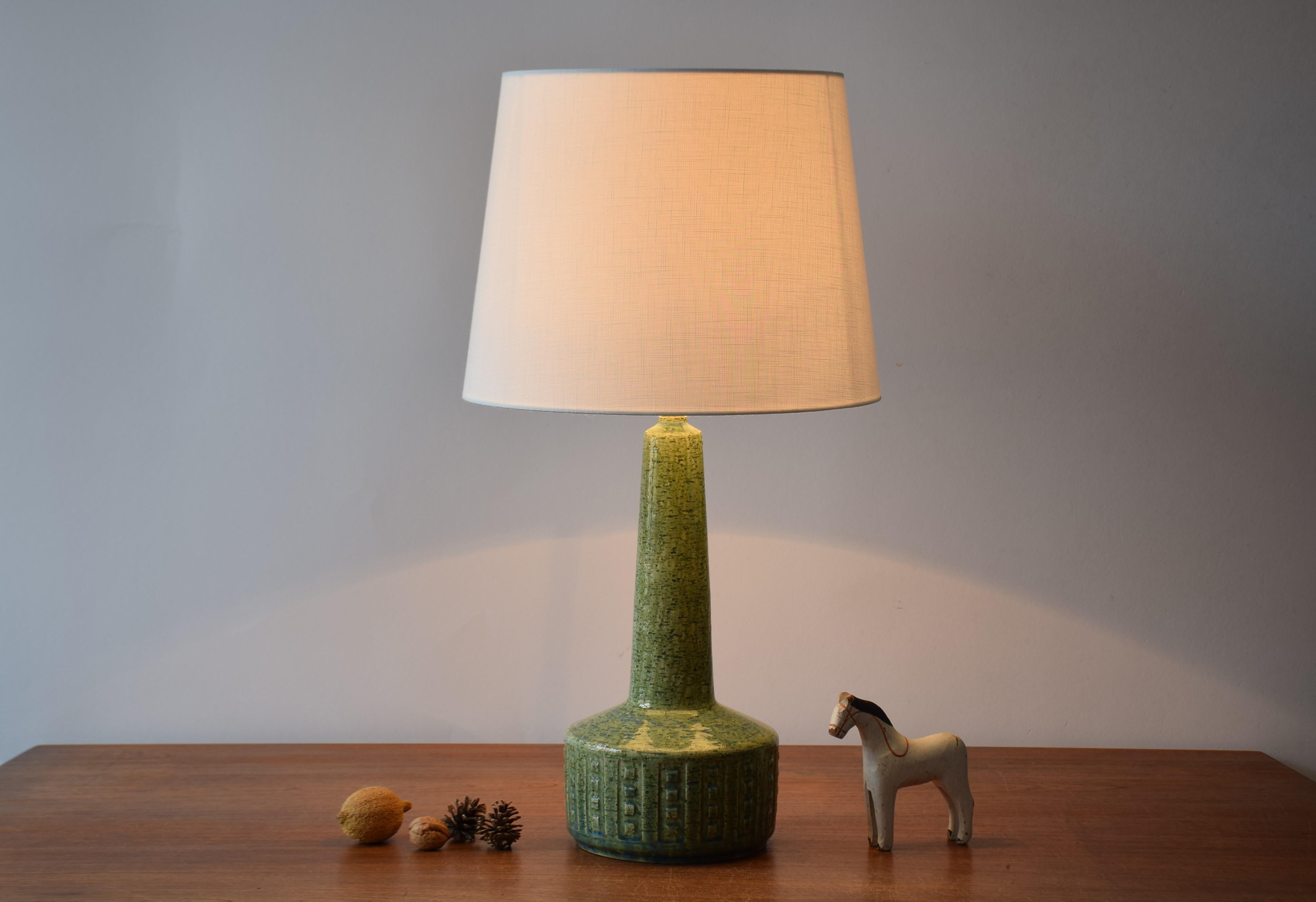 Midcentury tall table lamp from Danish Palshus.
The lamp was designed by Per Linnemann-Schmidt and produced, circa 1960s.
It is made with chamotte clay which gives a rough and vivid surface. The glaze is green with blue elements.

Included is a new