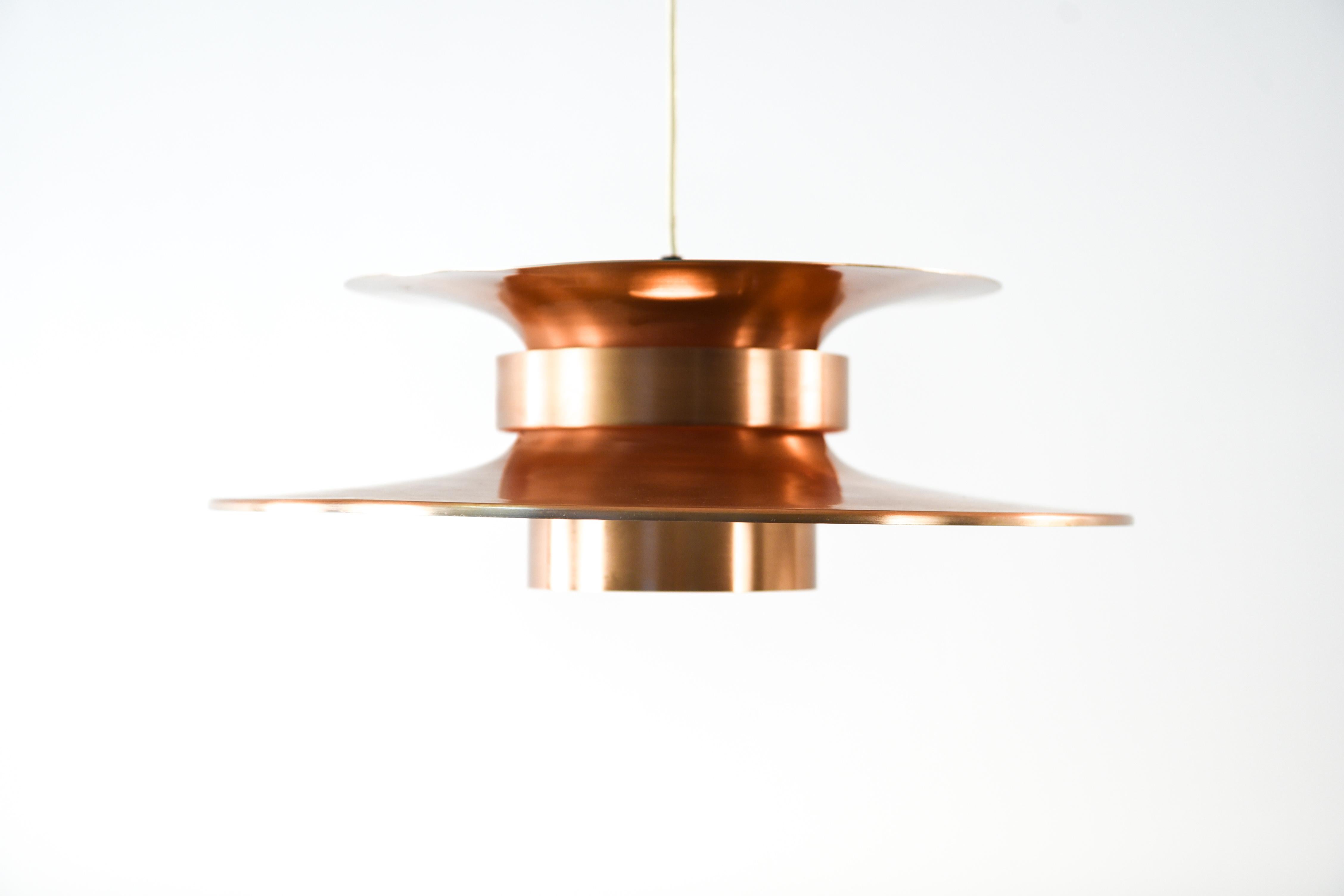 This Danish midcentury pendant light is a timeless shape that has retained its appeal through the ages. This chandelier's warm copper tone augments its interest while adding a sleek metallic element.