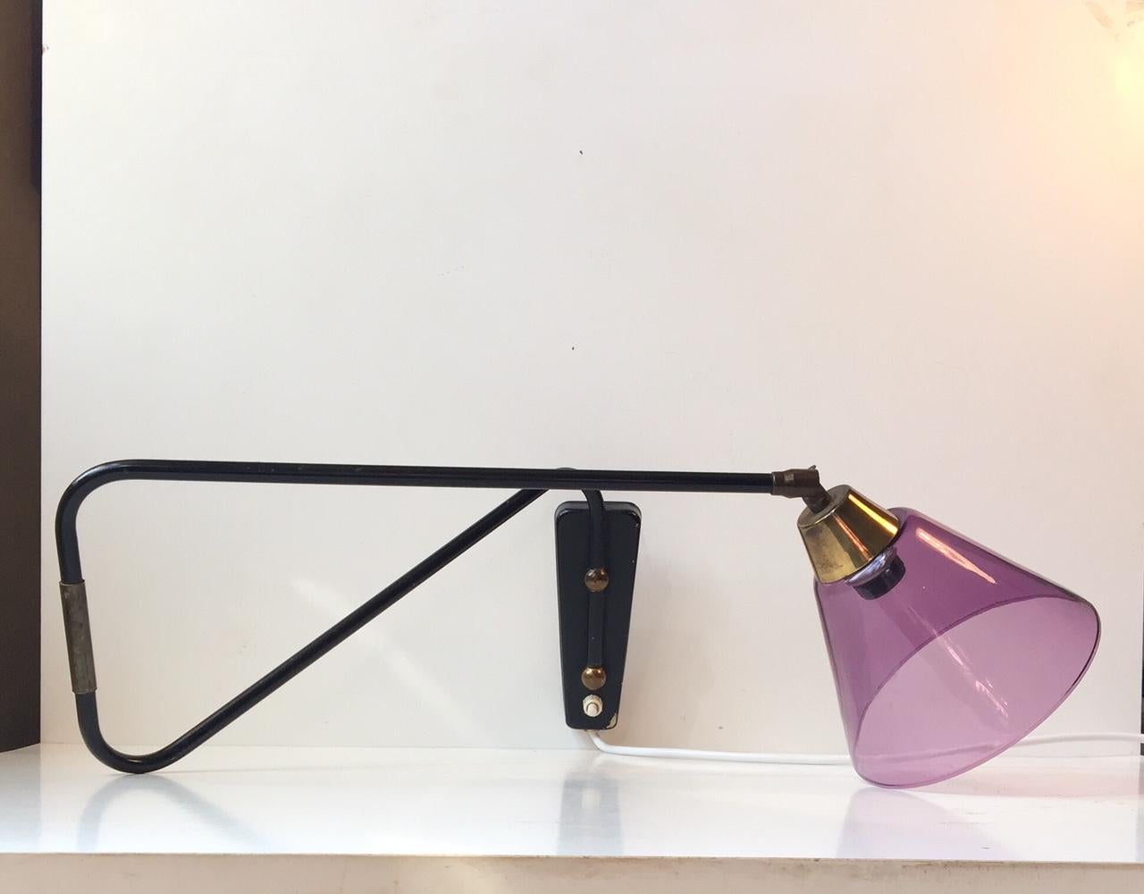 Fully adjustable wall lamp composed of steel, brass and a purple glass shade. It was possibly designed and manufactured by Th. Valentiner in Copenhagen. The style is reminiscent of Svend Aage Holm-Sørensen. The purple shade may have been a later